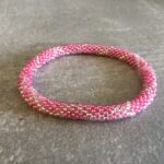 Roll-on perle armbåndene er håndlavet i Nepal. De er lavet med forskellige glasperler og i forskellige mønster. De er hæklet med en bomuldssnor. Syntes man at de lidt stramme, kan man vride forsigtigt i dem så de bliver større. syntes man derimod at de er blive lidt for løse, kan man ligge dem i vand. dette gør at bomildssnoren trækker sig sammen og de bliver mindre igen.