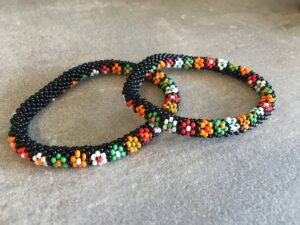 Roll-on perle armbåndene er håndlavet i Nepal. De er lavet med forskellige glasperler og i forskellige mønster. De er hæklet med en bomuldssnor. Syntes man at de lidt stramme, kan man vride forsigtigt i dem så de bliver større. syntes man derimod at de er blive lidt for løse, kan man ligge dem i vand. dette gør at bomildssnoren trækker sig sammen og de bliver mindre igen.