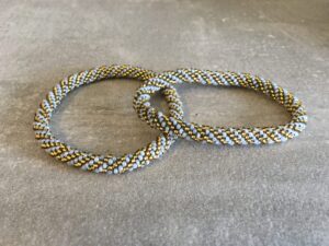Roll-on perle armbåndene er håndlavet i Nepal. De er lavet med forskellige glasperler og i forskellige mønster. De er hæklet med en bomuldssnor. Syntes man at de lidt stramme, kan man vride forsigtigt i dem så de bliver større. syntes man derimod at de er blive lidt for løse, kan man ligge dem i vand. dette gør at bomildssnoren trækker sig sammen og de bliver mindre igen.