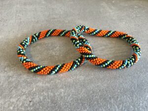 Roll-on perle armbåndene er håndlavet i Nepal. De er lavet med forskellige glasperler og i forskellige mønster. De er hæklet med en bomuldssnor. Syntes man at de lidt stramme, kan man vride forsigtigt i dem så de bliver større. syntes man derimod at de er blive lidt for løse, kan man ligge dem i vand. dette gør at bomildssnoren trækker sig sammen og de bliver mindre igen.