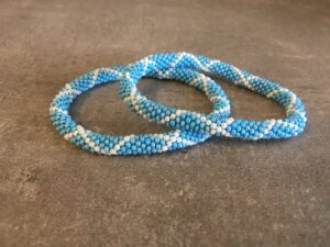 Roll-on perle armbåndene er håndlavet i Nepal. De er lavet med forskellige glasperler og i forskellige mønster. De er hæklet med en bomuldssnor. Syntes man at de lidt stramme, kan man vride forsigtigt i dem så de bliver større. syntes man derimod at de er blive lidt for løse, kan man ligge dem i vand. dette gør at bomildssnoren trækker sig sammen og de bliver mindre igen.