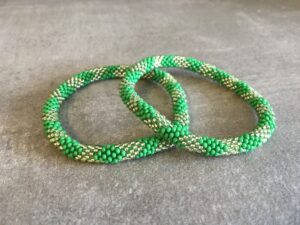 Roll-on perle armbåndene er håndlavet i Nepal. De er lavet med forskellige glasperler og i forskellige mønster. De er hæklet med en bomuldssnor. Syntes man at de lidt stramme, kan man vride forsigtigt i dem så de bliver større. syntes man derimod at de er blive lidt for løse, kan man ligge dem i vand. dette gør at bomildssnoren trækker sig sammen og de bliver mindre igen.