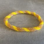 Roll-on perle armbåndene er håndlavet i Nepal. De er lavet med forskellige glasperler og i forskellige mønster. De er hæklet med en bomuldssnor. Syntes man at de lidt stramme, kan man vride forsigtigt i dem så de bliver større. syntes man derimod at de er blive lidt for løse, kan man ligge dem i vand. dette gør at bomildssnoren trækker sig sammen og de bliver mindre igen.