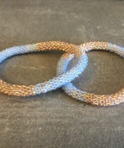 Roll-on perle armbåndene er håndlavet i Nepal. De er lavet med forskellige glasperler og i forskellige mønster. De er hæklet med en bomuldssnor. Syntes man at de lidt stramme, kan man vride forsigtigt i dem så de bliver større. syntes man derimod at de er blive lidt for løse, kan man ligge dem i vand. dette gør at bomildssnoren trækker sig sammen og de bliver mindre igen.