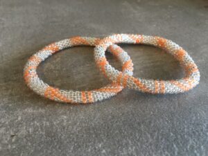 Roll-on perle armbåndene er håndlavet i Nepal. De er lavet med forskellige glasperler og i forskellige mønster. De er hæklet med en bomuldssnor. Syntes man at de lidt stramme, kan man vride forsigtigt i dem så de bliver større. syntes man derimod at de er blive lidt for løse, kan man ligge dem i vand. dette gør at bomildssnoren trækker sig sammen og de bliver mindre igen.