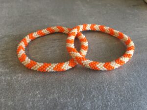 Roll-on perle armbåndene er håndlavet i Nepal. De er lavet med forskellige glasperler og i forskellige mønster. De er hæklet med en bomuldssnor. Syntes man at de lidt stramme, kan man vride forsigtigt i dem så de bliver større. syntes man derimod at de er blive lidt for løse, kan man ligge dem i vand. dette gør at bomildssnoren trækker sig sammen og de bliver mindre igen.