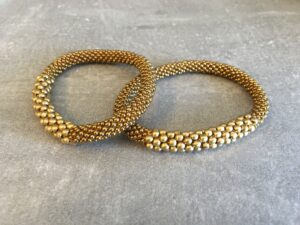 Roll-on perle armbåndene er håndlavet i Nepal. De er lavet med forskellige glasperler og i forskellige mønster. De er hæklet med en bomuldssnor. Syntes man at de lidt stramme, kan man vride forsigtigt i dem så de bliver større. syntes man derimod at de er blive lidt for løse, kan man ligge dem i vand. dette gør at bomildssnoren trækker sig sammen og de bliver mindre igen.