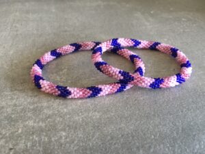 Roll-on perle armbåndene er håndlavet i Nepal. De er lavet med forskellige glasperler og i forskellige mønster. De er hæklet med en bomuldssnor. Syntes man at de lidt stramme, kan man vride forsigtigt i dem så de bliver større. syntes man derimod at de er blive lidt for løse, kan man ligge dem i vand. dette gør at bomildssnoren trækker sig sammen og de bliver mindre igen.