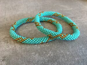 Roll-on perle armbåndene er håndlavet i Nepal. De er lavet med forskellige glasperler og i forskellige mønster. De er hæklet med en bomuldssnor. Syntes man at de lidt stramme, kan man vride forsigtigt i dem så de bliver større. syntes man derimod at de er blive lidt for løse, kan man ligge dem i vand. dette gør at bomildssnoren trækker sig sammen og de bliver mindre igen.