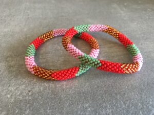 Roll-on perle armbåndene er håndlavet i Nepal. De er lavet med forskellige glasperler og i forskellige mønster. De er hæklet med en bomuldssnor. Syntes man at de lidt stramme, kan man vride forsigtigt i dem så de bliver større. syntes man derimod at de er blive lidt for løse, kan man ligge dem i vand. dette gør at bomildssnoren trækker sig sammen og de bliver mindre igen.