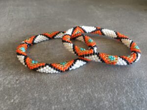 Roll-on perle armbåndene er håndlavet i Nepal. De er lavet med forskellige glasperler og i forskellige mønster. De er hæklet med en bomuldssnor. Syntes man at de lidt stramme, kan man vride forsigtigt i dem så de bliver større. syntes man derimod at de er blive lidt for løse, kan man ligge dem i vand. dette gør at bomildssnoren trækker sig sammen og de bliver mindre igen.