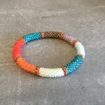 Roll-on perle armbåndene er håndlavet i Nepal. De er lavet med forskellige glasperler og i forskellige mønster. De er hæklet med en bomuldssnor. Syntes man at de lidt stramme, kan man vride forsigtigt i dem så de bliver større. syntes man derimod at de er blive lidt for løse, kan man ligge dem i vand. dette gør at bomildssnoren trækker sig sammen og de bliver mindre igen.