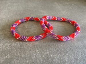 Roll-on perle armbåndene er håndlavet i Nepal. De er lavet med forskellige glasperler og i forskellige mønster. De er hæklet med en bomuldssnor. Syntes man at de lidt stramme, kan man vride forsigtigt i dem så de bliver større. syntes man derimod at de er blive lidt for løse, kan man ligge dem i vand. dette gør at bomildssnoren trækker sig sammen og de bliver mindre igen.