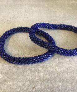 Roll-on perle armbåndene er håndlavet i Nepal. De er lavet med forskellige glasperler og i forskellige mønster. De er hæklet med en bomuldssnor. Syntes man at de lidt stramme, kan man vride forsigtigt i dem så de bliver større. syntes man derimod at de er blive lidt for løse, kan man ligge dem i vand. dette gør at bomildssnoren trækker sig sammen og de bliver mindre igen.