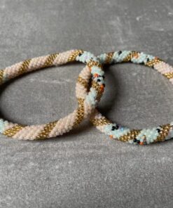 Nepal perle armbånd Nepal armbånd er en inspirerende og fascinerende smykkegenre, der vækker interessen hos smykkeentusiaster over hele verden. Disse håndlavede armbånd er kunstværker, der udstråler autenticitet, skønhed og dyb symbolik. Lad os dykke ned i den betagende verden af Nepal armbånd og udforske, hvad der gør dem så unikke og eftertragtede. Hvert Nepal armbånd er unikt, og det er netop denne individualitet, der appellerer til mange. Armbåndene er ofte skabt af dygtige nepalesiske håndværkere, der gennem generationer har forfinet deres teknikker til at skabe smykker af høj kvalitet. Disse håndværkere bruger traditionelle metoder, som har været en del af Nepals kultur og historie i århundreder. Processen er omhyggelig og kræver en stor grad af præcision og tålmodighed, hvilket gør hvert armbånd til en kærlighedsfyldt skabelse. Nepal armbånd er kendt for deres farverige og levende design. De er ofte dekoreret med perler, ædelstene, træ, metal eller andre naturlige materialer, hvilket giver dem et unikt udseende. Hvert enkelt element, der anvendes i armbåndene, er udvalgt omhyggeligt for at skabe en harmonisk kombination af farver og teksturer. Disse elementer er ofte inspireret af Nepals rige natur og kultur, hvilket giver armbåndene en autentisk følelse og en stærk forbindelse til landet. Symbolik spiller også en vigtig rolle i Nepal armbåndenes popularitet. Mange af armbåndene har indgraverede mønstre eller symboler, der repræsenterer vigtige aspekter af Nepals traditioner og spiritualitet. Disse symboler kan have betydning for held, lykke, kærlighed, beskyttelse eller en dybere forbindelse til naturen. At bære et Nepal armbånd kan derfor have en dybere betydning for bæreren og kan fungere som en påmindelse om deres forbindelse til Nepals rige arv. Nepal armbånd er ikke kun smukke smykker, men de har også en stærk social og kulturel betydning. Mange af disse smykker er håndlavede af kvinder, der er en del af samfundet i landområderne i Nepal. Produktionen af armbåndene giver disse kvinder mulighed for at skabe en bæredygtig indkomst, forbedre deres levevilkår og styrke deres selvstændighed. Når du køber et Nepal armbånd, bidrager du derfor til at støtte en positiv social indvirkning og bevare traditionelle håndværksmæssige metoder. Udover deres kulturelle og sociale betydning er Nepal armbånd også en favorit blandt modebevidste enkeltpersoner, der ønsker at tilføje en unik og autentisk touch til deres stil. Disse armbånd kan styles på utallige måder, uanset om du ønsker at skabe et bohemeinspireret look, en farverig festlig stil eller en subtil og elegant kombination. Der er et Nepal armbånd til enhver lejlighed og enhver personlig præference. I det store udvalg af smykker, der findes i dagens marked, skiller Nepal armbånd sig ud som en særlig perle. Deres håndlavede karakter, farverige design, dybe symbolik og sociale indvirkning gør dem til mere end bare smykker - de er en form for kunst og kultur, der fortæller historien om Nepal og dets folk. Ved at bære et Nepal armbånd, bærer du også med dig en del af dette rige og inspirerende land. Så uanset om du leder efter en meningsfuld gave eller ønsker at berige din egen smykkesamling, vil et Nepal armbånd være et mindeværdigt og værdsat valg.