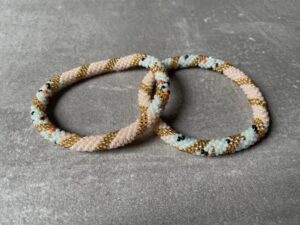 Nepal perle armbånd Nepal armbånd er en inspirerende og fascinerende smykkegenre, der vækker interessen hos smykkeentusiaster over hele verden. Disse håndlavede armbånd er kunstværker, der udstråler autenticitet, skønhed og dyb symbolik. Lad os dykke ned i den betagende verden af Nepal armbånd og udforske, hvad der gør dem så unikke og eftertragtede. Hvert Nepal armbånd er unikt, og det er netop denne individualitet, der appellerer til mange. Armbåndene er ofte skabt af dygtige nepalesiske håndværkere, der gennem generationer har forfinet deres teknikker til at skabe smykker af høj kvalitet. Disse håndværkere bruger traditionelle metoder, som har været en del af Nepals kultur og historie i århundreder. Processen er omhyggelig og kræver en stor grad af præcision og tålmodighed, hvilket gør hvert armbånd til en kærlighedsfyldt skabelse. Nepal armbånd er kendt for deres farverige og levende design. De er ofte dekoreret med perler, ædelstene, træ, metal eller andre naturlige materialer, hvilket giver dem et unikt udseende. Hvert enkelt element, der anvendes i armbåndene, er udvalgt omhyggeligt for at skabe en harmonisk kombination af farver og teksturer. Disse elementer er ofte inspireret af Nepals rige natur og kultur, hvilket giver armbåndene en autentisk følelse og en stærk forbindelse til landet. Symbolik spiller også en vigtig rolle i Nepal armbåndenes popularitet. Mange af armbåndene har indgraverede mønstre eller symboler, der repræsenterer vigtige aspekter af Nepals traditioner og spiritualitet. Disse symboler kan have betydning for held, lykke, kærlighed, beskyttelse eller en dybere forbindelse til naturen. At bære et Nepal armbånd kan derfor have en dybere betydning for bæreren og kan fungere som en påmindelse om deres forbindelse til Nepals rige arv. Nepal armbånd er ikke kun smukke smykker, men de har også en stærk social og kulturel betydning. Mange af disse smykker er håndlavede af kvinder, der er en del af samfundet i landområderne i Nepal. Produktionen af armbåndene giver disse kvinder mulighed for at skabe en bæredygtig indkomst, forbedre deres levevilkår og styrke deres selvstændighed. Når du køber et Nepal armbånd, bidrager du derfor til at støtte en positiv social indvirkning og bevare traditionelle håndværksmæssige metoder. Udover deres kulturelle og sociale betydning er Nepal armbånd også en favorit blandt modebevidste enkeltpersoner, der ønsker at tilføje en unik og autentisk touch til deres stil. Disse armbånd kan styles på utallige måder, uanset om du ønsker at skabe et bohemeinspireret look, en farverig festlig stil eller en subtil og elegant kombination. Der er et Nepal armbånd til enhver lejlighed og enhver personlig præference. I det store udvalg af smykker, der findes i dagens marked, skiller Nepal armbånd sig ud som en særlig perle. Deres håndlavede karakter, farverige design, dybe symbolik og sociale indvirkning gør dem til mere end bare smykker - de er en form for kunst og kultur, der fortæller historien om Nepal og dets folk. Ved at bære et Nepal armbånd, bærer du også med dig en del af dette rige og inspirerende land. Så uanset om du leder efter en meningsfuld gave eller ønsker at berige din egen smykkesamling, vil et Nepal armbånd være et mindeværdigt og værdsat valg.