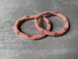 Nepal perle armbånd Nepal armbånd er en inspirerende og fascinerende smykkegenre, der vækker interessen hos smykkeentusiaster over hele verden. Disse håndlavede armbånd er kunstværker, der udstråler autenticitet, skønhed og dyb symbolik. Lad os dykke ned i den betagende verden af Nepal armbånd og udforske, hvad der gør dem så unikke og eftertragtede. Hvert Nepal armbånd er unikt, og det er netop denne individualitet, der appellerer til mange. Armbåndene er ofte skabt af dygtige nepalesiske håndværkere, der gennem generationer har forfinet deres teknikker til at skabe smykker af høj kvalitet. Disse håndværkere bruger traditionelle metoder, som har været en del af Nepals kultur og historie i århundreder. Processen er omhyggelig og kræver en stor grad af præcision og tålmodighed, hvilket gør hvert armbånd til en kærlighedsfyldt skabelse. Nepal armbånd er kendt for deres farverige og levende design. De er ofte dekoreret med perler, ædelstene, træ, metal eller andre naturlige materialer, hvilket giver dem et unikt udseende. Hvert enkelt element, der anvendes i armbåndene, er udvalgt omhyggeligt for at skabe en harmonisk kombination af farver og teksturer. Disse elementer er ofte inspireret af Nepals rige natur og kultur, hvilket giver armbåndene en autentisk følelse og en stærk forbindelse til landet. Symbolik spiller også en vigtig rolle i Nepal armbåndenes popularitet. Mange af armbåndene har indgraverede mønstre eller symboler, der repræsenterer vigtige aspekter af Nepals traditioner og spiritualitet. Disse symboler kan have betydning for held, lykke, kærlighed, beskyttelse eller en dybere forbindelse til naturen. At bære et Nepal armbånd kan derfor have en dybere betydning for bæreren og kan fungere som en påmindelse om deres forbindelse til Nepals rige arv. Nepal armbånd er ikke kun smukke smykker, men de har også en stærk social og kulturel betydning. Mange af disse smykker er håndlavede af kvinder, der er en del af samfundet i landområderne i Nepal. Produktionen af armbåndene giver disse kvinder mulighed for at skabe en bæredygtig indkomst, forbedre deres levevilkår og styrke deres selvstændighed. Når du køber et Nepal armbånd, bidrager du derfor til at støtte en positiv social indvirkning og bevare traditionelle håndværksmæssige metoder. Udover deres kulturelle og sociale betydning er Nepal armbånd også en favorit blandt modebevidste enkeltpersoner, der ønsker at tilføje en unik og autentisk touch til deres stil. Disse armbånd kan styles på utallige måder, uanset om du ønsker at skabe et bohemeinspireret look, en farverig festlig stil eller en subtil og elegant kombination. Der er et Nepal armbånd til enhver lejlighed og enhver personlig præference. I det store udvalg af smykker, der findes i dagens marked, skiller Nepal armbånd sig ud som en særlig perle. Deres håndlavede karakter, farverige design, dybe symbolik og sociale indvirkning gør dem til mere end bare smykker - de er en form for kunst og kultur, der fortæller historien om Nepal og dets folk. Ved at bære et Nepal armbånd, bærer du også med dig en del af dette rige og inspirerende land. Så uanset om du leder efter en meningsfuld gave eller ønsker at berige din egen smykkesamling, vil et Nepal armbånd være et mindeværdigt og værdsat valg.
