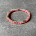 Nepal perle armbånd Nepal armbånd er en inspirerende og fascinerende smykkegenre, der vækker interessen hos smykkeentusiaster over hele verden. Disse håndlavede armbånd er kunstværker, der udstråler autenticitet, skønhed og dyb symbolik. Lad os dykke ned i den betagende verden af Nepal armbånd og udforske, hvad der gør dem så unikke og eftertragtede. Hvert Nepal armbånd er unikt, og det er netop denne individualitet, der appellerer til mange. Armbåndene er ofte skabt af dygtige nepalesiske håndværkere, der gennem generationer har forfinet deres teknikker til at skabe smykker af høj kvalitet. Disse håndværkere bruger traditionelle metoder, som har været en del af Nepals kultur og historie i århundreder. Processen er omhyggelig og kræver en stor grad af præcision og tålmodighed, hvilket gør hvert armbånd til en kærlighedsfyldt skabelse. Nepal armbånd er kendt for deres farverige og levende design. De er ofte dekoreret med perler, ædelstene, træ, metal eller andre naturlige materialer, hvilket giver dem et unikt udseende. Hvert enkelt element, der anvendes i armbåndene, er udvalgt omhyggeligt for at skabe en harmonisk kombination af farver og teksturer. Disse elementer er ofte inspireret af Nepals rige natur og kultur, hvilket giver armbåndene en autentisk følelse og en stærk forbindelse til landet. Symbolik spiller også en vigtig rolle i Nepal armbåndenes popularitet. Mange af armbåndene har indgraverede mønstre eller symboler, der repræsenterer vigtige aspekter af Nepals traditioner og spiritualitet. Disse symboler kan have betydning for held, lykke, kærlighed, beskyttelse eller en dybere forbindelse til naturen. At bære et Nepal armbånd kan derfor have en dybere betydning for bæreren og kan fungere som en påmindelse om deres forbindelse til Nepals rige arv. Nepal armbånd er ikke kun smukke smykker, men de har også en stærk social og kulturel betydning. Mange af disse smykker er håndlavede af kvinder, der er en del af samfundet i landområderne i Nepal. Produktionen af armbåndene giver disse kvinder mulighed for at skabe en bæredygtig indkomst, forbedre deres levevilkår og styrke deres selvstændighed. Når du køber et Nepal armbånd, bidrager du derfor til at støtte en positiv social indvirkning og bevare traditionelle håndværksmæssige metoder. Udover deres kulturelle og sociale betydning er Nepal armbånd også en favorit blandt modebevidste enkeltpersoner, der ønsker at tilføje en unik og autentisk touch til deres stil. Disse armbånd kan styles på utallige måder, uanset om du ønsker at skabe et bohemeinspireret look, en farverig festlig stil eller en subtil og elegant kombination. Der er et Nepal armbånd til enhver lejlighed og enhver personlig præference. I det store udvalg af smykker, der findes i dagens marked, skiller Nepal armbånd sig ud som en særlig perle. Deres håndlavede karakter, farverige design, dybe symbolik og sociale indvirkning gør dem til mere end bare smykker - de er en form for kunst og kultur, der fortæller historien om Nepal og dets folk. Ved at bære et Nepal armbånd, bærer du også med dig en del af dette rige og inspirerende land. Så uanset om du leder efter en meningsfuld gave eller ønsker at berige din egen smykkesamling, vil et Nepal armbånd være et mindeværdigt og værdsat valg.