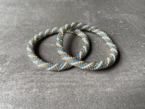 Nepal perle armbånd Nepal armbånd er en inspirerende og fascinerende smykkegenre, der vækker interessen hos smykkeentusiaster over hele verden. Disse håndlavede armbånd er kunstværker, der udstråler autenticitet, skønhed og dyb symbolik. Lad os dykke ned i den betagende verden af Nepal armbånd og udforske, hvad der gør dem så unikke og eftertragtede. Hvert Nepal armbånd er unikt, og det er netop denne individualitet, der appellerer til mange. Armbåndene er ofte skabt af dygtige nepalesiske håndværkere, der gennem generationer har forfinet deres teknikker til at skabe smykker af høj kvalitet. Disse håndværkere bruger traditionelle metoder, som har været en del af Nepals kultur og historie i århundreder. Processen er omhyggelig og kræver en stor grad af præcision og tålmodighed, hvilket gør hvert armbånd til en kærlighedsfyldt skabelse. Nepal armbånd er kendt for deres farverige og levende design. De er ofte dekoreret med perler, ædelstene, træ, metal eller andre naturlige materialer, hvilket giver dem et unikt udseende. Hvert enkelt element, der anvendes i armbåndene, er udvalgt omhyggeligt for at skabe en harmonisk kombination af farver og teksturer. Disse elementer er ofte inspireret af Nepals rige natur og kultur, hvilket giver armbåndene en autentisk følelse og en stærk forbindelse til landet. Symbolik spiller også en vigtig rolle i Nepal armbåndenes popularitet. Mange af armbåndene har indgraverede mønstre eller symboler, der repræsenterer vigtige aspekter af Nepals traditioner og spiritualitet. Disse symboler kan have betydning for held, lykke, kærlighed, beskyttelse eller en dybere forbindelse til naturen. At bære et Nepal armbånd kan derfor have en dybere betydning for bæreren og kan fungere som en påmindelse om deres forbindelse til Nepals rige arv. Nepal armbånd er ikke kun smukke smykker, men de har også en stærk social og kulturel betydning. Mange af disse smykker er håndlavede af kvinder, der er en del af samfundet i landområderne i Nepal. Produktionen af armbåndene giver disse kvinder mulighed for at skabe en bæredygtig indkomst, forbedre deres levevilkår og styrke deres selvstændighed. Når du køber et Nepal armbånd, bidrager du derfor til at støtte en positiv social indvirkning og bevare traditionelle håndværksmæssige metoder. Udover deres kulturelle og sociale betydning er Nepal armbånd også en favorit blandt modebevidste enkeltpersoner, der ønsker at tilføje en unik og autentisk touch til deres stil. Disse armbånd kan styles på utallige måder, uanset om du ønsker at skabe et bohemeinspireret look, en farverig festlig stil eller en subtil og elegant kombination. Der er et Nepal armbånd til enhver lejlighed og enhver personlig præference. I det store udvalg af smykker, der findes i dagens marked, skiller Nepal armbånd sig ud som en særlig perle. Deres håndlavede karakter, farverige design, dybe symbolik og sociale indvirkning gør dem til mere end bare smykker - de er en form for kunst og kultur, der fortæller historien om Nepal og dets folk. Ved at bære et Nepal armbånd, bærer du også med dig en del af dette rige og inspirerende land. Så uanset om du leder efter en meningsfuld gave eller ønsker at berige din egen smykkesamling, vil et Nepal armbånd være et mindeværdigt og værdsat valg.