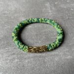 Nepal perle armbånd Nepal armbånd er en inspirerende og fascinerende smykkegenre, der vækker interessen hos smykkeentusiaster over hele verden. Disse håndlavede armbånd er kunstværker, der udstråler autenticitet, skønhed og dyb symbolik. Lad os dykke ned i den betagende verden af Nepal armbånd og udforske, hvad der gør dem så unikke og eftertragtede. Hvert Nepal armbånd er unikt, og det er netop denne individualitet, der appellerer til mange. Armbåndene er ofte skabt af dygtige nepalesiske håndværkere, der gennem generationer har forfinet deres teknikker til at skabe smykker af høj kvalitet. Disse håndværkere bruger traditionelle metoder, som har været en del af Nepals kultur og historie i århundreder. Processen er omhyggelig og kræver en stor grad af præcision og tålmodighed, hvilket gør hvert armbånd til en kærlighedsfyldt skabelse. Nepal armbånd er kendt for deres farverige og levende design. De er ofte dekoreret med perler, ædelstene, træ, metal eller andre naturlige materialer, hvilket giver dem et unikt udseende. Hvert enkelt element, der anvendes i armbåndene, er udvalgt omhyggeligt for at skabe en harmonisk kombination af farver og teksturer. Disse elementer er ofte inspireret af Nepals rige natur og kultur, hvilket giver armbåndene en autentisk følelse og en stærk forbindelse til landet. Symbolik spiller også en vigtig rolle i Nepal armbåndenes popularitet. Mange af armbåndene har indgraverede mønstre eller symboler, der repræsenterer vigtige aspekter af Nepals traditioner og spiritualitet. Disse symboler kan have betydning for held, lykke, kærlighed, beskyttelse eller en dybere forbindelse til naturen. At bære et Nepal armbånd kan derfor have en dybere betydning for bæreren og kan fungere som en påmindelse om deres forbindelse til Nepals rige arv. Nepal armbånd er ikke kun smukke smykker, men de har også en stærk social og kulturel betydning. Mange af disse smykker er håndlavede af kvinder, der er en del af samfundet i landområderne i Nepal. Produktionen af armbåndene giver disse kvinder mulighed for at skabe en bæredygtig indkomst, forbedre deres levevilkår og styrke deres selvstændighed. Når du køber et Nepal armbånd, bidrager du derfor til at støtte en positiv social indvirkning og bevare traditionelle håndværksmæssige metoder. Udover deres kulturelle og sociale betydning er Nepal armbånd også en favorit blandt modebevidste enkeltpersoner, der ønsker at tilføje en unik og autentisk touch til deres stil. Disse armbånd kan styles på utallige måder, uanset om du ønsker at skabe et bohemeinspireret look, en farverig festlig stil eller en subtil og elegant kombination. Der er et Nepal armbånd til enhver lejlighed og enhver personlig præference. I det store udvalg af smykker, der findes i dagens marked, skiller Nepal armbånd sig ud som en særlig perle. Deres håndlavede karakter, farverige design, dybe symbolik og sociale indvirkning gør dem til mere end bare smykker - de er en form for kunst og kultur, der fortæller historien om Nepal og dets folk. Ved at bære et Nepal armbånd, bærer du også med dig en del af dette rige og inspirerende land. Så uanset om du leder efter en meningsfuld gave eller ønsker at berige din egen smykkesamling, vil et Nepal armbånd være et mindeværdigt og værdsat valg.