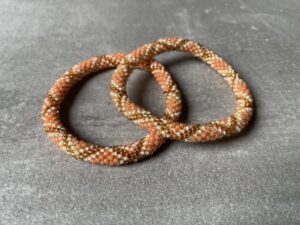 Nepal perle armbånd Nepal armbånd er en inspirerende og fascinerende smykkegenre, der vækker interessen hos smykkeentusiaster over hele verden. Disse håndlavede armbånd er kunstværker, der udstråler autenticitet, skønhed og dyb symbolik. Lad os dykke ned i den betagende verden af Nepal armbånd og udforske, hvad der gør dem så unikke og eftertragtede. Hvert Nepal armbånd er unikt, og det er netop denne individualitet, der appellerer til mange. Armbåndene er ofte skabt af dygtige nepalesiske håndværkere, der gennem generationer har forfinet deres teknikker til at skabe smykker af høj kvalitet. Disse håndværkere bruger traditionelle metoder, som har været en del af Nepals kultur og historie i århundreder. Processen er omhyggelig og kræver en stor grad af præcision og tålmodighed, hvilket gør hvert armbånd til en kærlighedsfyldt skabelse. Nepal armbånd er kendt for deres farverige og levende design. De er ofte dekoreret med perler, ædelstene, træ, metal eller andre naturlige materialer, hvilket giver dem et unikt udseende. Hvert enkelt element, der anvendes i armbåndene, er udvalgt omhyggeligt for at skabe en harmonisk kombination af farver og teksturer. Disse elementer er ofte inspireret af Nepals rige natur og kultur, hvilket giver armbåndene en autentisk følelse og en stærk forbindelse til landet. Symbolik spiller også en vigtig rolle i Nepal armbåndenes popularitet. Mange af armbåndene har indgraverede mønstre eller symboler, der repræsenterer vigtige aspekter af Nepals traditioner og spiritualitet. Disse symboler kan have betydning for held, lykke, kærlighed, beskyttelse eller en dybere forbindelse til naturen. At bære et Nepal armbånd kan derfor have en dybere betydning for bæreren og kan fungere som en påmindelse om deres forbindelse til Nepals rige arv. Nepal armbånd er ikke kun smukke smykker, men de har også en stærk social og kulturel betydning. Mange af disse smykker er håndlavede af kvinder, der er en del af samfundet i landområderne i Nepal. Produktionen af armbåndene giver disse kvinder mulighed for at skabe en bæredygtig indkomst, forbedre deres levevilkår og styrke deres selvstændighed. Når du køber et Nepal armbånd, bidrager du derfor til at støtte en positiv social indvirkning og bevare traditionelle håndværksmæssige metoder. Udover deres kulturelle og sociale betydning er Nepal armbånd også en favorit blandt modebevidste enkeltpersoner, der ønsker at tilføje en unik og autentisk touch til deres stil. Disse armbånd kan styles på utallige måder, uanset om du ønsker at skabe et bohemeinspireret look, en farverig festlig stil eller en subtil og elegant kombination. Der er et Nepal armbånd til enhver lejlighed og enhver personlig præference. I det store udvalg af smykker, der findes i dagens marked, skiller Nepal armbånd sig ud som en særlig perle. Deres håndlavede karakter, farverige design, dybe symbolik og sociale indvirkning gør dem til mere end bare smykker - de er en form for kunst og kultur, der fortæller historien om Nepal og dets folk. Ved at bære et Nepal armbånd, bærer du også med dig en del af dette rige og inspirerende land. Så uanset om du leder efter en meningsfuld gave eller ønsker at berige din egen smykkesamling, vil et Nepal armbånd være et mindeværdigt og værdsat valg.