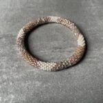Nepal perle armbånd Nepal armbånd er en inspirerende og fascinerende smykkegenre, der vækker interessen hos smykkeentusiaster over hele verden. Disse håndlavede armbånd er kunstværker, der udstråler autenticitet, skønhed og dyb symbolik. Lad os dykke ned i den betagende verden af Nepal armbånd og udforske, hvad der gør dem så unikke og eftertragtede. Hvert Nepal armbånd er unikt, og det er netop denne individualitet, der appellerer til mange. Armbåndene er ofte skabt af dygtige nepalesiske håndværkere, der gennem generationer har forfinet deres teknikker til at skabe smykker af høj kvalitet. Disse håndværkere bruger traditionelle metoder, som har været en del af Nepals kultur og historie i århundreder. Processen er omhyggelig og kræver en stor grad af præcision og tålmodighed, hvilket gør hvert armbånd til en kærlighedsfyldt skabelse. Nepal armbånd er kendt for deres farverige og levende design. De er ofte dekoreret med perler, ædelstene, træ, metal eller andre naturlige materialer, hvilket giver dem et unikt udseende. Hvert enkelt element, der anvendes i armbåndene, er udvalgt omhyggeligt for at skabe en harmonisk kombination af farver og teksturer. Disse elementer er ofte inspireret af Nepals rige natur og kultur, hvilket giver armbåndene en autentisk følelse og en stærk forbindelse til landet. Symbolik spiller også en vigtig rolle i Nepal armbåndenes popularitet. Mange af armbåndene har indgraverede mønstre eller symboler, der repræsenterer vigtige aspekter af Nepals traditioner og spiritualitet. Disse symboler kan have betydning for held, lykke, kærlighed, beskyttelse eller en dybere forbindelse til naturen. At bære et Nepal armbånd kan derfor have en dybere betydning for bæreren og kan fungere som en påmindelse om deres forbindelse til Nepals rige arv. Nepal armbånd er ikke kun smukke smykker, men de har også en stærk social og kulturel betydning. Mange af disse smykker er håndlavede af kvinder, der er en del af samfundet i landområderne i Nepal. Produktionen af armbåndene giver disse kvinder mulighed for at skabe en bæredygtig indkomst, forbedre deres levevilkår og styrke deres selvstændighed. Når du køber et Nepal armbånd, bidrager du derfor til at støtte en positiv social indvirkning og bevare traditionelle håndværksmæssige metoder. Udover deres kulturelle og sociale betydning er Nepal armbånd også en favorit blandt modebevidste enkeltpersoner, der ønsker at tilføje en unik og autentisk touch til deres stil. Disse armbånd kan styles på utallige måder, uanset om du ønsker at skabe et bohemeinspireret look, en farverig festlig stil eller en subtil og elegant kombination. Der er et Nepal armbånd til enhver lejlighed og enhver personlig præference. I det store udvalg af smykker, der findes i dagens marked, skiller Nepal armbånd sig ud som en særlig perle. Deres håndlavede karakter, farverige design, dybe symbolik og sociale indvirkning gør dem til mere end bare smykker - de er en form for kunst og kultur, der fortæller historien om Nepal og dets folk. Ved at bære et Nepal armbånd, bærer du også med dig en del af dette rige og inspirerende land. Så uanset om du leder efter en meningsfuld gave eller ønsker at berige din egen smykkesamling, vil et Nepal armbånd være et mindeværdigt og værdsat valg.