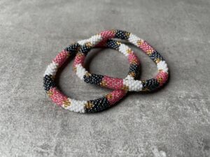 Nepal perle armbånd Nepal armbånd er en inspirerende og fascinerende smykkegenre, der vækker interessen hos smykkeentusiaster over hele verden. Disse håndlavede armbånd er kunstværker, der udstråler autenticitet, skønhed og dyb symbolik. Lad os dykke ned i den betagende verden af Nepal armbånd og udforske, hvad der gør dem så unikke og eftertragtede. Hvert Nepal armbånd er unikt, og det er netop denne individualitet, der appellerer til mange. Armbåndene er ofte skabt af dygtige nepalesiske håndværkere, der gennem generationer har forfinet deres teknikker til at skabe smykker af høj kvalitet. Disse håndværkere bruger traditionelle metoder, som har været en del af Nepals kultur og historie i århundreder. Processen er omhyggelig og kræver en stor grad af præcision og tålmodighed, hvilket gør hvert armbånd til en kærlighedsfyldt skabelse. Nepal armbånd er kendt for deres farverige og levende design. De er ofte dekoreret med perler, ædelstene, træ, metal eller andre naturlige materialer, hvilket giver dem et unikt udseende. Hvert enkelt element, der anvendes i armbåndene, er udvalgt omhyggeligt for at skabe en harmonisk kombination af farver og teksturer. Disse elementer er ofte inspireret af Nepals rige natur og kultur, hvilket giver armbåndene en autentisk følelse og en stærk forbindelse til landet. Symbolik spiller også en vigtig rolle i Nepal armbåndenes popularitet. Mange af armbåndene har indgraverede mønstre eller symboler, der repræsenterer vigtige aspekter af Nepals traditioner og spiritualitet. Disse symboler kan have betydning for held, lykke, kærlighed, beskyttelse eller en dybere forbindelse til naturen. At bære et Nepal armbånd kan derfor have en dybere betydning for bæreren og kan fungere som en påmindelse om deres forbindelse til Nepals rige arv. Nepal armbånd er ikke kun smukke smykker, men de har også en stærk social og kulturel betydning. Mange af disse smykker er håndlavede af kvinder, der er en del af samfundet i landområderne i Nepal. Produktionen af armbåndene giver disse kvinder mulighed for at skabe en bæredygtig indkomst, forbedre deres levevilkår og styrke deres selvstændighed. Når du køber et Nepal armbånd, bidrager du derfor til at støtte en positiv social indvirkning og bevare traditionelle håndværksmæssige metoder. Udover deres kulturelle og sociale betydning er Nepal armbånd også en favorit blandt modebevidste enkeltpersoner, der ønsker at tilføje en unik og autentisk touch til deres stil. Disse armbånd kan styles på utallige måder, uanset om du ønsker at skabe et bohemeinspireret look, en farverig festlig stil eller en subtil og elegant kombination. Der er et Nepal armbånd til enhver lejlighed og enhver personlig præference. I det store udvalg af smykker, der findes i dagens marked, skiller Nepal armbånd sig ud som en særlig perle. Deres håndlavede karakter, farverige design, dybe symbolik og sociale indvirkning gør dem til mere end bare smykker - de er en form for kunst og kultur, der fortæller historien om Nepal og dets folk. Ved at bære et Nepal armbånd, bærer du også med dig en del af dette rige og inspirerende land. Så uanset om du leder efter en meningsfuld gave eller ønsker at berige din egen smykkesamling, vil et Nepal armbånd være et mindeværdigt og værdsat valg.