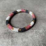Nepal perle armbånd Nepal armbånd er en inspirerende og fascinerende smykkegenre, der vækker interessen hos smykkeentusiaster over hele verden. Disse håndlavede armbånd er kunstværker, der udstråler autenticitet, skønhed og dyb symbolik. Lad os dykke ned i den betagende verden af Nepal armbånd og udforske, hvad der gør dem så unikke og eftertragtede. Hvert Nepal armbånd er unikt, og det er netop denne individualitet, der appellerer til mange. Armbåndene er ofte skabt af dygtige nepalesiske håndværkere, der gennem generationer har forfinet deres teknikker til at skabe smykker af høj kvalitet. Disse håndværkere bruger traditionelle metoder, som har været en del af Nepals kultur og historie i århundreder. Processen er omhyggelig og kræver en stor grad af præcision og tålmodighed, hvilket gør hvert armbånd til en kærlighedsfyldt skabelse. Nepal armbånd er kendt for deres farverige og levende design. De er ofte dekoreret med perler, ædelstene, træ, metal eller andre naturlige materialer, hvilket giver dem et unikt udseende. Hvert enkelt element, der anvendes i armbåndene, er udvalgt omhyggeligt for at skabe en harmonisk kombination af farver og teksturer. Disse elementer er ofte inspireret af Nepals rige natur og kultur, hvilket giver armbåndene en autentisk følelse og en stærk forbindelse til landet. Symbolik spiller også en vigtig rolle i Nepal armbåndenes popularitet. Mange af armbåndene har indgraverede mønstre eller symboler, der repræsenterer vigtige aspekter af Nepals traditioner og spiritualitet. Disse symboler kan have betydning for held, lykke, kærlighed, beskyttelse eller en dybere forbindelse til naturen. At bære et Nepal armbånd kan derfor have en dybere betydning for bæreren og kan fungere som en påmindelse om deres forbindelse til Nepals rige arv. Nepal armbånd er ikke kun smukke smykker, men de har også en stærk social og kulturel betydning. Mange af disse smykker er håndlavede af kvinder, der er en del af samfundet i landområderne i Nepal. Produktionen af armbåndene giver disse kvinder mulighed for at skabe en bæredygtig indkomst, forbedre deres levevilkår og styrke deres selvstændighed. Når du køber et Nepal armbånd, bidrager du derfor til at støtte en positiv social indvirkning og bevare traditionelle håndværksmæssige metoder. Udover deres kulturelle og sociale betydning er Nepal armbånd også en favorit blandt modebevidste enkeltpersoner, der ønsker at tilføje en unik og autentisk touch til deres stil. Disse armbånd kan styles på utallige måder, uanset om du ønsker at skabe et bohemeinspireret look, en farverig festlig stil eller en subtil og elegant kombination. Der er et Nepal armbånd til enhver lejlighed og enhver personlig præference. I det store udvalg af smykker, der findes i dagens marked, skiller Nepal armbånd sig ud som en særlig perle. Deres håndlavede karakter, farverige design, dybe symbolik og sociale indvirkning gør dem til mere end bare smykker - de er en form for kunst og kultur, der fortæller historien om Nepal og dets folk. Ved at bære et Nepal armbånd, bærer du også med dig en del af dette rige og inspirerende land. Så uanset om du leder efter en meningsfuld gave eller ønsker at berige din egen smykkesamling, vil et Nepal armbånd være et mindeværdigt og værdsat valg.