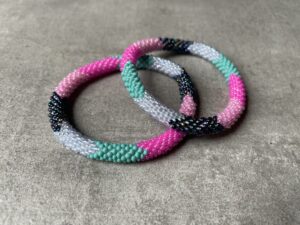 Nepal perle armbånd Nepal armbånd er en inspirerende og fascinerende smykkegenre, der vækker interessen hos smykkeentusiaster over hele verden. Disse håndlavede armbånd er kunstværker, der udstråler autenticitet, skønhed og dyb symbolik. Lad os dykke ned i den betagende verden af Nepal armbånd og udforske, hvad der gør dem så unikke og eftertragtede. Hvert Nepal armbånd er unikt, og det er netop denne individualitet, der appellerer til mange. Armbåndene er ofte skabt af dygtige nepalesiske håndværkere, der gennem generationer har forfinet deres teknikker til at skabe smykker af høj kvalitet. Disse håndværkere bruger traditionelle metoder, som har været en del af Nepals kultur og historie i århundreder. Processen er omhyggelig og kræver en stor grad af præcision og tålmodighed, hvilket gør hvert armbånd til en kærlighedsfyldt skabelse. Nepal armbånd er kendt for deres farverige og levende design. De er ofte dekoreret med perler, ædelstene, træ, metal eller andre naturlige materialer, hvilket giver dem et unikt udseende. Hvert enkelt element, der anvendes i armbåndene, er udvalgt omhyggeligt for at skabe en harmonisk kombination af farver og teksturer. Disse elementer er ofte inspireret af Nepals rige natur og kultur, hvilket giver armbåndene en autentisk følelse og en stærk forbindelse til landet. Symbolik spiller også en vigtig rolle i Nepal armbåndenes popularitet. Mange af armbåndene har indgraverede mønstre eller symboler, der repræsenterer vigtige aspekter af Nepals traditioner og spiritualitet. Disse symboler kan have betydning for held, lykke, kærlighed, beskyttelse eller en dybere forbindelse til naturen. At bære et Nepal armbånd kan derfor have en dybere betydning for bæreren og kan fungere som en påmindelse om deres forbindelse til Nepals rige arv. Nepal armbånd er ikke kun smukke smykker, men de har også en stærk social og kulturel betydning. Mange af disse smykker er håndlavede af kvinder, der er en del af samfundet i landområderne i Nepal. Produktionen af armbåndene giver disse kvinder mulighed for at skabe en bæredygtig indkomst, forbedre deres levevilkår og styrke deres selvstændighed. Når du køber et Nepal armbånd, bidrager du derfor til at støtte en positiv social indvirkning og bevare traditionelle håndværksmæssige metoder. Udover deres kulturelle og sociale betydning er Nepal armbånd også en favorit blandt modebevidste enkeltpersoner, der ønsker at tilføje en unik og autentisk touch til deres stil. Disse armbånd kan styles på utallige måder, uanset om du ønsker at skabe et bohemeinspireret look, en farverig festlig stil eller en subtil og elegant kombination. Der er et Nepal armbånd til enhver lejlighed og enhver personlig præference. I det store udvalg af smykker, der findes i dagens marked, skiller Nepal armbånd sig ud som en særlig perle. Deres håndlavede karakter, farverige design, dybe symbolik og sociale indvirkning gør dem til mere end bare smykker - de er en form for kunst og kultur, der fortæller historien om Nepal og dets folk. Ved at bære et Nepal armbånd, bærer du også med dig en del af dette rige og inspirerende land. Så uanset om du leder efter en meningsfuld gave eller ønsker at berige din egen smykkesamling, vil et Nepal armbånd være et mindeværdigt og værdsat valg.