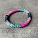 Nepal perle armbånd Nepal armbånd er en inspirerende og fascinerende smykkegenre, der vækker interessen hos smykkeentusiaster over hele verden. Disse håndlavede armbånd er kunstværker, der udstråler autenticitet, skønhed og dyb symbolik. Lad os dykke ned i den betagende verden af Nepal armbånd og udforske, hvad der gør dem så unikke og eftertragtede. Hvert Nepal armbånd er unikt, og det er netop denne individualitet, der appellerer til mange. Armbåndene er ofte skabt af dygtige nepalesiske håndværkere, der gennem generationer har forfinet deres teknikker til at skabe smykker af høj kvalitet. Disse håndværkere bruger traditionelle metoder, som har været en del af Nepals kultur og historie i århundreder. Processen er omhyggelig og kræver en stor grad af præcision og tålmodighed, hvilket gør hvert armbånd til en kærlighedsfyldt skabelse. Nepal armbånd er kendt for deres farverige og levende design. De er ofte dekoreret med perler, ædelstene, træ, metal eller andre naturlige materialer, hvilket giver dem et unikt udseende. Hvert enkelt element, der anvendes i armbåndene, er udvalgt omhyggeligt for at skabe en harmonisk kombination af farver og teksturer. Disse elementer er ofte inspireret af Nepals rige natur og kultur, hvilket giver armbåndene en autentisk følelse og en stærk forbindelse til landet. Symbolik spiller også en vigtig rolle i Nepal armbåndenes popularitet. Mange af armbåndene har indgraverede mønstre eller symboler, der repræsenterer vigtige aspekter af Nepals traditioner og spiritualitet. Disse symboler kan have betydning for held, lykke, kærlighed, beskyttelse eller en dybere forbindelse til naturen. At bære et Nepal armbånd kan derfor have en dybere betydning for bæreren og kan fungere som en påmindelse om deres forbindelse til Nepals rige arv. Nepal armbånd er ikke kun smukke smykker, men de har også en stærk social og kulturel betydning. Mange af disse smykker er håndlavede af kvinder, der er en del af samfundet i landområderne i Nepal. Produktionen af armbåndene giver disse kvinder mulighed for at skabe en bæredygtig indkomst, forbedre deres levevilkår og styrke deres selvstændighed. Når du køber et Nepal armbånd, bidrager du derfor til at støtte en positiv social indvirkning og bevare traditionelle håndværksmæssige metoder. Udover deres kulturelle og sociale betydning er Nepal armbånd også en favorit blandt modebevidste enkeltpersoner, der ønsker at tilføje en unik og autentisk touch til deres stil. Disse armbånd kan styles på utallige måder, uanset om du ønsker at skabe et bohemeinspireret look, en farverig festlig stil eller en subtil og elegant kombination. Der er et Nepal armbånd til enhver lejlighed og enhver personlig præference. I det store udvalg af smykker, der findes i dagens marked, skiller Nepal armbånd sig ud som en særlig perle. Deres håndlavede karakter, farverige design, dybe symbolik og sociale indvirkning gør dem til mere end bare smykker - de er en form for kunst og kultur, der fortæller historien om Nepal og dets folk. Ved at bære et Nepal armbånd, bærer du også med dig en del af dette rige og inspirerende land. Så uanset om du leder efter en meningsfuld gave eller ønsker at berige din egen smykkesamling, vil et Nepal armbånd være et mindeværdigt og værdsat valg.