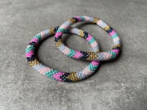Nepal perle armbånd Nepal armbånd er en inspirerende og fascinerende smykkegenre, der vækker interessen hos smykkeentusiaster over hele verden. Disse håndlavede armbånd er kunstværker, der udstråler autenticitet, skønhed og dyb symbolik. Lad os dykke ned i den betagende verden af Nepal armbånd og udforske, hvad der gør dem så unikke og eftertragtede. Hvert Nepal armbånd er unikt, og det er netop denne individualitet, der appellerer til mange. Armbåndene er ofte skabt af dygtige nepalesiske håndværkere, der gennem generationer har forfinet deres teknikker til at skabe smykker af høj kvalitet. Disse håndværkere bruger traditionelle metoder, som har været en del af Nepals kultur og historie i århundreder. Processen er omhyggelig og kræver en stor grad af præcision og tålmodighed, hvilket gør hvert armbånd til en kærlighedsfyldt skabelse. Nepal armbånd er kendt for deres farverige og levende design. De er ofte dekoreret med perler, ædelstene, træ, metal eller andre naturlige materialer, hvilket giver dem et unikt udseende. Hvert enkelt element, der anvendes i armbåndene, er udvalgt omhyggeligt for at skabe en harmonisk kombination af farver og teksturer. Disse elementer er ofte inspireret af Nepals rige natur og kultur, hvilket giver armbåndene en autentisk følelse og en stærk forbindelse til landet. Symbolik spiller også en vigtig rolle i Nepal armbåndenes popularitet. Mange af armbåndene har indgraverede mønstre eller symboler, der repræsenterer vigtige aspekter af Nepals traditioner og spiritualitet. Disse symboler kan have betydning for held, lykke, kærlighed, beskyttelse eller en dybere forbindelse til naturen. At bære et Nepal armbånd kan derfor have en dybere betydning for bæreren og kan fungere som en påmindelse om deres forbindelse til Nepals rige arv. Nepal armbånd er ikke kun smukke smykker, men de har også en stærk social og kulturel betydning. Mange af disse smykker er håndlavede af kvinder, der er en del af samfundet i landområderne i Nepal. Produktionen af armbåndene giver disse kvinder mulighed for at skabe en bæredygtig indkomst, forbedre deres levevilkår og styrke deres selvstændighed. Når du køber et Nepal armbånd, bidrager du derfor til at støtte en positiv social indvirkning og bevare traditionelle håndværksmæssige metoder. Udover deres kulturelle og sociale betydning er Nepal armbånd også en favorit blandt modebevidste enkeltpersoner, der ønsker at tilføje en unik og autentisk touch til deres stil. Disse armbånd kan styles på utallige måder, uanset om du ønsker at skabe et bohemeinspireret look, en farverig festlig stil eller en subtil og elegant kombination. Der er et Nepal armbånd til enhver lejlighed og enhver personlig præference. I det store udvalg af smykker, der findes i dagens marked, skiller Nepal armbånd sig ud som en særlig perle. Deres håndlavede karakter, farverige design, dybe symbolik og sociale indvirkning gør dem til mere end bare smykker - de er en form for kunst og kultur, der fortæller historien om Nepal og dets folk. Ved at bære et Nepal armbånd, bærer du også med dig en del af dette rige og inspirerende land. Så uanset om du leder efter en meningsfuld gave eller ønsker at berige din egen smykkesamling, vil et Nepal armbånd være et mindeværdigt og værdsat valg.