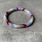 Nepal perle armbånd Nepal armbånd er en inspirerende og fascinerende smykkegenre, der vækker interessen hos smykkeentusiaster over hele verden. Disse håndlavede armbånd er kunstværker, der udstråler autenticitet, skønhed og dyb symbolik. Lad os dykke ned i den betagende verden af Nepal armbånd og udforske, hvad der gør dem så unikke og eftertragtede. Hvert Nepal armbånd er unikt, og det er netop denne individualitet, der appellerer til mange. Armbåndene er ofte skabt af dygtige nepalesiske håndværkere, der gennem generationer har forfinet deres teknikker til at skabe smykker af høj kvalitet. Disse håndværkere bruger traditionelle metoder, som har været en del af Nepals kultur og historie i århundreder. Processen er omhyggelig og kræver en stor grad af præcision og tålmodighed, hvilket gør hvert armbånd til en kærlighedsfyldt skabelse. Nepal armbånd er kendt for deres farverige og levende design. De er ofte dekoreret med perler, ædelstene, træ, metal eller andre naturlige materialer, hvilket giver dem et unikt udseende. Hvert enkelt element, der anvendes i armbåndene, er udvalgt omhyggeligt for at skabe en harmonisk kombination af farver og teksturer. Disse elementer er ofte inspireret af Nepals rige natur og kultur, hvilket giver armbåndene en autentisk følelse og en stærk forbindelse til landet. Symbolik spiller også en vigtig rolle i Nepal armbåndenes popularitet. Mange af armbåndene har indgraverede mønstre eller symboler, der repræsenterer vigtige aspekter af Nepals traditioner og spiritualitet. Disse symboler kan have betydning for held, lykke, kærlighed, beskyttelse eller en dybere forbindelse til naturen. At bære et Nepal armbånd kan derfor have en dybere betydning for bæreren og kan fungere som en påmindelse om deres forbindelse til Nepals rige arv. Nepal armbånd er ikke kun smukke smykker, men de har også en stærk social og kulturel betydning. Mange af disse smykker er håndlavede af kvinder, der er en del af samfundet i landområderne i Nepal. Produktionen af armbåndene giver disse kvinder mulighed for at skabe en bæredygtig indkomst, forbedre deres levevilkår og styrke deres selvstændighed. Når du køber et Nepal armbånd, bidrager du derfor til at støtte en positiv social indvirkning og bevare traditionelle håndværksmæssige metoder. Udover deres kulturelle og sociale betydning er Nepal armbånd også en favorit blandt modebevidste enkeltpersoner, der ønsker at tilføje en unik og autentisk touch til deres stil. Disse armbånd kan styles på utallige måder, uanset om du ønsker at skabe et bohemeinspireret look, en farverig festlig stil eller en subtil og elegant kombination. Der er et Nepal armbånd til enhver lejlighed og enhver personlig præference. I det store udvalg af smykker, der findes i dagens marked, skiller Nepal armbånd sig ud som en særlig perle. Deres håndlavede karakter, farverige design, dybe symbolik og sociale indvirkning gør dem til mere end bare smykker - de er en form for kunst og kultur, der fortæller historien om Nepal og dets folk. Ved at bære et Nepal armbånd, bærer du også med dig en del af dette rige og inspirerende land. Så uanset om du leder efter en meningsfuld gave eller ønsker at berige din egen smykkesamling, vil et Nepal armbånd være et mindeværdigt og værdsat valg.