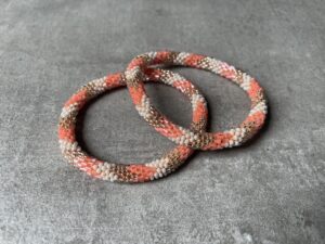 Nepal perle armbånd Nepal armbånd er en inspirerende og fascinerende smykkegenre, der vækker interessen hos smykkeentusiaster over hele verden. Disse håndlavede armbånd er kunstværker, der udstråler autenticitet, skønhed og dyb symbolik. Lad os dykke ned i den betagende verden af Nepal armbånd og udforske, hvad der gør dem så unikke og eftertragtede. Hvert Nepal armbånd er unikt, og det er netop denne individualitet, der appellerer til mange. Armbåndene er ofte skabt af dygtige nepalesiske håndværkere, der gennem generationer har forfinet deres teknikker til at skabe smykker af høj kvalitet. Disse håndværkere bruger traditionelle metoder, som har været en del af Nepals kultur og historie i århundreder. Processen er omhyggelig og kræver en stor grad af præcision og tålmodighed, hvilket gør hvert armbånd til en kærlighedsfyldt skabelse. Nepal armbånd er kendt for deres farverige og levende design. De er ofte dekoreret med perler, ædelstene, træ, metal eller andre naturlige materialer, hvilket giver dem et unikt udseende. Hvert enkelt element, der anvendes i armbåndene, er udvalgt omhyggeligt for at skabe en harmonisk kombination af farver og teksturer. Disse elementer er ofte inspireret af Nepals rige natur og kultur, hvilket giver armbåndene en autentisk følelse og en stærk forbindelse til landet. Symbolik spiller også en vigtig rolle i Nepal armbåndenes popularitet. Mange af armbåndene har indgraverede mønstre eller symboler, der repræsenterer vigtige aspekter af Nepals traditioner og spiritualitet. Disse symboler kan have betydning for held, lykke, kærlighed, beskyttelse eller en dybere forbindelse til naturen. At bære et Nepal armbånd kan derfor have en dybere betydning for bæreren og kan fungere som en påmindelse om deres forbindelse til Nepals rige arv. Nepal armbånd er ikke kun smukke smykker, men de har også en stærk social og kulturel betydning. Mange af disse smykker er håndlavede af kvinder, der er en del af samfundet i landområderne i Nepal. Produktionen af armbåndene giver disse kvinder mulighed for at skabe en bæredygtig indkomst, forbedre deres levevilkår og styrke deres selvstændighed. Når du køber et Nepal armbånd, bidrager du derfor til at støtte en positiv social indvirkning og bevare traditionelle håndværksmæssige metoder. Udover deres kulturelle og sociale betydning er Nepal armbånd også en favorit blandt modebevidste enkeltpersoner, der ønsker at tilføje en unik og autentisk touch til deres stil. Disse armbånd kan styles på utallige måder, uanset om du ønsker at skabe et bohemeinspireret look, en farverig festlig stil eller en subtil og elegant kombination. Der er et Nepal armbånd til enhver lejlighed og enhver personlig præference. I det store udvalg af smykker, der findes i dagens marked, skiller Nepal armbånd sig ud som en særlig perle. Deres håndlavede karakter, farverige design, dybe symbolik og sociale indvirkning gør dem til mere end bare smykker - de er en form for kunst og kultur, der fortæller historien om Nepal og dets folk. Ved at bære et Nepal armbånd, bærer du også med dig en del af dette rige og inspirerende land. Så uanset om du leder efter en meningsfuld gave eller ønsker at berige din egen smykkesamling, vil et Nepal armbånd være et mindeværdigt og værdsat valg.
