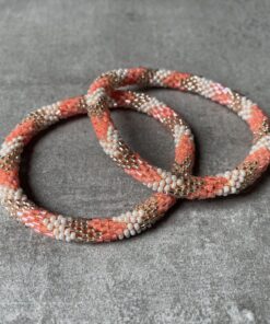 Nepal perle armbånd Nepal armbånd er en inspirerende og fascinerende smykkegenre, der vækker interessen hos smykkeentusiaster over hele verden. Disse håndlavede armbånd er kunstværker, der udstråler autenticitet, skønhed og dyb symbolik. Lad os dykke ned i den betagende verden af Nepal armbånd og udforske, hvad der gør dem så unikke og eftertragtede. Hvert Nepal armbånd er unikt, og det er netop denne individualitet, der appellerer til mange. Armbåndene er ofte skabt af dygtige nepalesiske håndværkere, der gennem generationer har forfinet deres teknikker til at skabe smykker af høj kvalitet. Disse håndværkere bruger traditionelle metoder, som har været en del af Nepals kultur og historie i århundreder. Processen er omhyggelig og kræver en stor grad af præcision og tålmodighed, hvilket gør hvert armbånd til en kærlighedsfyldt skabelse. Nepal armbånd er kendt for deres farverige og levende design. De er ofte dekoreret med perler, ædelstene, træ, metal eller andre naturlige materialer, hvilket giver dem et unikt udseende. Hvert enkelt element, der anvendes i armbåndene, er udvalgt omhyggeligt for at skabe en harmonisk kombination af farver og teksturer. Disse elementer er ofte inspireret af Nepals rige natur og kultur, hvilket giver armbåndene en autentisk følelse og en stærk forbindelse til landet. Symbolik spiller også en vigtig rolle i Nepal armbåndenes popularitet. Mange af armbåndene har indgraverede mønstre eller symboler, der repræsenterer vigtige aspekter af Nepals traditioner og spiritualitet. Disse symboler kan have betydning for held, lykke, kærlighed, beskyttelse eller en dybere forbindelse til naturen. At bære et Nepal armbånd kan derfor have en dybere betydning for bæreren og kan fungere som en påmindelse om deres forbindelse til Nepals rige arv. Nepal armbånd er ikke kun smukke smykker, men de har også en stærk social og kulturel betydning. Mange af disse smykker er håndlavede af kvinder, der er en del af samfundet i landområderne i Nepal. Produktionen af armbåndene giver disse kvinder mulighed for at skabe en bæredygtig indkomst, forbedre deres levevilkår og styrke deres selvstændighed. Når du køber et Nepal armbånd, bidrager du derfor til at støtte en positiv social indvirkning og bevare traditionelle håndværksmæssige metoder. Udover deres kulturelle og sociale betydning er Nepal armbånd også en favorit blandt modebevidste enkeltpersoner, der ønsker at tilføje en unik og autentisk touch til deres stil. Disse armbånd kan styles på utallige måder, uanset om du ønsker at skabe et bohemeinspireret look, en farverig festlig stil eller en subtil og elegant kombination. Der er et Nepal armbånd til enhver lejlighed og enhver personlig præference. I det store udvalg af smykker, der findes i dagens marked, skiller Nepal armbånd sig ud som en særlig perle. Deres håndlavede karakter, farverige design, dybe symbolik og sociale indvirkning gør dem til mere end bare smykker - de er en form for kunst og kultur, der fortæller historien om Nepal og dets folk. Ved at bære et Nepal armbånd, bærer du også med dig en del af dette rige og inspirerende land. Så uanset om du leder efter en meningsfuld gave eller ønsker at berige din egen smykkesamling, vil et Nepal armbånd være et mindeværdigt og værdsat valg.