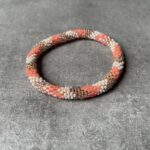 Nepal perle armbånd Nepal armbånd er en inspirerende og fascinerende smykkegenre, der vækker interessen hos smykkeentusiaster over hele verden. Disse håndlavede armbånd er kunstværker, der udstråler autenticitet, skønhed og dyb symbolik. Lad os dykke ned i den betagende verden af Nepal armbånd og udforske, hvad der gør dem så unikke og eftertragtede. Hvert Nepal armbånd er unikt, og det er netop denne individualitet, der appellerer til mange. Armbåndene er ofte skabt af dygtige nepalesiske håndværkere, der gennem generationer har forfinet deres teknikker til at skabe smykker af høj kvalitet. Disse håndværkere bruger traditionelle metoder, som har været en del af Nepals kultur og historie i århundreder. Processen er omhyggelig og kræver en stor grad af præcision og tålmodighed, hvilket gør hvert armbånd til en kærlighedsfyldt skabelse. Nepal armbånd er kendt for deres farverige og levende design. De er ofte dekoreret med perler, ædelstene, træ, metal eller andre naturlige materialer, hvilket giver dem et unikt udseende. Hvert enkelt element, der anvendes i armbåndene, er udvalgt omhyggeligt for at skabe en harmonisk kombination af farver og teksturer. Disse elementer er ofte inspireret af Nepals rige natur og kultur, hvilket giver armbåndene en autentisk følelse og en stærk forbindelse til landet. Symbolik spiller også en vigtig rolle i Nepal armbåndenes popularitet. Mange af armbåndene har indgraverede mønstre eller symboler, der repræsenterer vigtige aspekter af Nepals traditioner og spiritualitet. Disse symboler kan have betydning for held, lykke, kærlighed, beskyttelse eller en dybere forbindelse til naturen. At bære et Nepal armbånd kan derfor have en dybere betydning for bæreren og kan fungere som en påmindelse om deres forbindelse til Nepals rige arv. Nepal armbånd er ikke kun smukke smykker, men de har også en stærk social og kulturel betydning. Mange af disse smykker er håndlavede af kvinder, der er en del af samfundet i landområderne i Nepal. Produktionen af armbåndene giver disse kvinder mulighed for at skabe en bæredygtig indkomst, forbedre deres levevilkår og styrke deres selvstændighed. Når du køber et Nepal armbånd, bidrager du derfor til at støtte en positiv social indvirkning og bevare traditionelle håndværksmæssige metoder. Udover deres kulturelle og sociale betydning er Nepal armbånd også en favorit blandt modebevidste enkeltpersoner, der ønsker at tilføje en unik og autentisk touch til deres stil. Disse armbånd kan styles på utallige måder, uanset om du ønsker at skabe et bohemeinspireret look, en farverig festlig stil eller en subtil og elegant kombination. Der er et Nepal armbånd til enhver lejlighed og enhver personlig præference. I det store udvalg af smykker, der findes i dagens marked, skiller Nepal armbånd sig ud som en særlig perle. Deres håndlavede karakter, farverige design, dybe symbolik og sociale indvirkning gør dem til mere end bare smykker - de er en form for kunst og kultur, der fortæller historien om Nepal og dets folk. Ved at bære et Nepal armbånd, bærer du også med dig en del af dette rige og inspirerende land. Så uanset om du leder efter en meningsfuld gave eller ønsker at berige din egen smykkesamling, vil et Nepal armbånd være et mindeværdigt og værdsat valg.