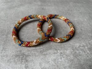 Nepal perle armbånd Nepal armbånd er en inspirerende og fascinerende smykkegenre, der vækker interessen hos smykkeentusiaster over hele verden. Disse håndlavede armbånd er kunstværker, der udstråler autenticitet, skønhed og dyb symbolik. Lad os dykke ned i den betagende verden af Nepal armbånd og udforske, hvad der gør dem så unikke og eftertragtede. Hvert Nepal armbånd er unikt, og det er netop denne individualitet, der appellerer til mange. Armbåndene er ofte skabt af dygtige nepalesiske håndværkere, der gennem generationer har forfinet deres teknikker til at skabe smykker af høj kvalitet. Disse håndværkere bruger traditionelle metoder, som har været en del af Nepals kultur og historie i århundreder. Processen er omhyggelig og kræver en stor grad af præcision og tålmodighed, hvilket gør hvert armbånd til en kærlighedsfyldt skabelse. Nepal armbånd er kendt for deres farverige og levende design. De er ofte dekoreret med perler, ædelstene, træ, metal eller andre naturlige materialer, hvilket giver dem et unikt udseende. Hvert enkelt element, der anvendes i armbåndene, er udvalgt omhyggeligt for at skabe en harmonisk kombination af farver og teksturer. Disse elementer er ofte inspireret af Nepals rige natur og kultur, hvilket giver armbåndene en autentisk følelse og en stærk forbindelse til landet. Symbolik spiller også en vigtig rolle i Nepal armbåndenes popularitet. Mange af armbåndene har indgraverede mønstre eller symboler, der repræsenterer vigtige aspekter af Nepals traditioner og spiritualitet. Disse symboler kan have betydning for held, lykke, kærlighed, beskyttelse eller en dybere forbindelse til naturen. At bære et Nepal armbånd kan derfor have en dybere betydning for bæreren og kan fungere som en påmindelse om deres forbindelse til Nepals rige arv. Nepal armbånd er ikke kun smukke smykker, men de har også en stærk social og kulturel betydning. Mange af disse smykker er håndlavede af kvinder, der er en del af samfundet i landområderne i Nepal. Produktionen af armbåndene giver disse kvinder mulighed for at skabe en bæredygtig indkomst, forbedre deres levevilkår og styrke deres selvstændighed. Når du køber et Nepal armbånd, bidrager du derfor til at støtte en positiv social indvirkning og bevare traditionelle håndværksmæssige metoder. Udover deres kulturelle og sociale betydning er Nepal armbånd også en favorit blandt modebevidste enkeltpersoner, der ønsker at tilføje en unik og autentisk touch til deres stil. Disse armbånd kan styles på utallige måder, uanset om du ønsker at skabe et bohemeinspireret look, en farverig festlig stil eller en subtil og elegant kombination. Der er et Nepal armbånd til enhver lejlighed og enhver personlig præference. I det store udvalg af smykker, der findes i dagens marked, skiller Nepal armbånd sig ud som en særlig perle. Deres håndlavede karakter, farverige design, dybe symbolik og sociale indvirkning gør dem til mere end bare smykker - de er en form for kunst og kultur, der fortæller historien om Nepal og dets folk. Ved at bære et Nepal armbånd, bærer du også med dig en del af dette rige og inspirerende land. Så uanset om du leder efter en meningsfuld gave eller ønsker at berige din egen smykkesamling, vil et Nepal armbånd være et mindeværdigt og værdsat valg.