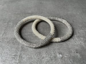 Nepal perle armbånd Nepal armbånd er en inspirerende og fascinerende smykkegenre, der vækker interessen hos smykkeentusiaster over hele verden. Disse håndlavede armbånd er kunstværker, der udstråler autenticitet, skønhed og dyb symbolik. Lad os dykke ned i den betagende verden af Nepal armbånd og udforske, hvad der gør dem så unikke og eftertragtede. Hvert Nepal armbånd er unikt, og det er netop denne individualitet, der appellerer til mange. Armbåndene er ofte skabt af dygtige nepalesiske håndværkere, der gennem generationer har forfinet deres teknikker til at skabe smykker af høj kvalitet. Disse håndværkere bruger traditionelle metoder, som har været en del af Nepals kultur og historie i århundreder. Processen er omhyggelig og kræver en stor grad af præcision og tålmodighed, hvilket gør hvert armbånd til en kærlighedsfyldt skabelse. Nepal armbånd er kendt for deres farverige og levende design. De er ofte dekoreret med perler, ædelstene, træ, metal eller andre naturlige materialer, hvilket giver dem et unikt udseende. Hvert enkelt element, der anvendes i armbåndene, er udvalgt omhyggeligt for at skabe en harmonisk kombination af farver og teksturer. Disse elementer er ofte inspireret af Nepals rige natur og kultur, hvilket giver armbåndene en autentisk følelse og en stærk forbindelse til landet. Symbolik spiller også en vigtig rolle i Nepal armbåndenes popularitet. Mange af armbåndene har indgraverede mønstre eller symboler, der repræsenterer vigtige aspekter af Nepals traditioner og spiritualitet. Disse symboler kan have betydning for held, lykke, kærlighed, beskyttelse eller en dybere forbindelse til naturen. At bære et Nepal armbånd kan derfor have en dybere betydning for bæreren og kan fungere som en påmindelse om deres forbindelse til Nepals rige arv. Nepal armbånd er ikke kun smukke smykker, men de har også en stærk social og kulturel betydning. Mange af disse smykker er håndlavede af kvinder, der er en del af samfundet i landområderne i Nepal. Produktionen af armbåndene giver disse kvinder mulighed for at skabe en bæredygtig indkomst, forbedre deres levevilkår og styrke deres selvstændighed. Når du køber et Nepal armbånd, bidrager du derfor til at støtte en positiv social indvirkning og bevare traditionelle håndværksmæssige metoder. Udover deres kulturelle og sociale betydning er Nepal armbånd også en favorit blandt modebevidste enkeltpersoner, der ønsker at tilføje en unik og autentisk touch til deres stil. Disse armbånd kan styles på utallige måder, uanset om du ønsker at skabe et bohemeinspireret look, en farverig festlig stil eller en subtil og elegant kombination. Der er et Nepal armbånd til enhver lejlighed og enhver personlig præference. I det store udvalg af smykker, der findes i dagens marked, skiller Nepal armbånd sig ud som en særlig perle. Deres håndlavede karakter, farverige design, dybe symbolik og sociale indvirkning gør dem til mere end bare smykker - de er en form for kunst og kultur, der fortæller historien om Nepal og dets folk. Ved at bære et Nepal armbånd, bærer du også med dig en del af dette rige og inspirerende land. Så uanset om du leder efter en meningsfuld gave eller ønsker at berige din egen smykkesamling, vil et Nepal armbånd være et mindeværdigt og værdsat valg.