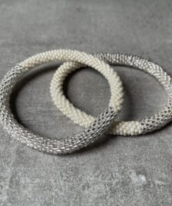 Nepal perle armbånd Nepal armbånd er en inspirerende og fascinerende smykkegenre, der vækker interessen hos smykkeentusiaster over hele verden. Disse håndlavede armbånd er kunstværker, der udstråler autenticitet, skønhed og dyb symbolik. Lad os dykke ned i den betagende verden af Nepal armbånd og udforske, hvad der gør dem så unikke og eftertragtede. Hvert Nepal armbånd er unikt, og det er netop denne individualitet, der appellerer til mange. Armbåndene er ofte skabt af dygtige nepalesiske håndværkere, der gennem generationer har forfinet deres teknikker til at skabe smykker af høj kvalitet. Disse håndværkere bruger traditionelle metoder, som har været en del af Nepals kultur og historie i århundreder. Processen er omhyggelig og kræver en stor grad af præcision og tålmodighed, hvilket gør hvert armbånd til en kærlighedsfyldt skabelse. Nepal armbånd er kendt for deres farverige og levende design. De er ofte dekoreret med perler, ædelstene, træ, metal eller andre naturlige materialer, hvilket giver dem et unikt udseende. Hvert enkelt element, der anvendes i armbåndene, er udvalgt omhyggeligt for at skabe en harmonisk kombination af farver og teksturer. Disse elementer er ofte inspireret af Nepals rige natur og kultur, hvilket giver armbåndene en autentisk følelse og en stærk forbindelse til landet. Symbolik spiller også en vigtig rolle i Nepal armbåndenes popularitet. Mange af armbåndene har indgraverede mønstre eller symboler, der repræsenterer vigtige aspekter af Nepals traditioner og spiritualitet. Disse symboler kan have betydning for held, lykke, kærlighed, beskyttelse eller en dybere forbindelse til naturen. At bære et Nepal armbånd kan derfor have en dybere betydning for bæreren og kan fungere som en påmindelse om deres forbindelse til Nepals rige arv. Nepal armbånd er ikke kun smukke smykker, men de har også en stærk social og kulturel betydning. Mange af disse smykker er håndlavede af kvinder, der er en del af samfundet i landområderne i Nepal. Produktionen af armbåndene giver disse kvinder mulighed for at skabe en bæredygtig indkomst, forbedre deres levevilkår og styrke deres selvstændighed. Når du køber et Nepal armbånd, bidrager du derfor til at støtte en positiv social indvirkning og bevare traditionelle håndværksmæssige metoder. Udover deres kulturelle og sociale betydning er Nepal armbånd også en favorit blandt modebevidste enkeltpersoner, der ønsker at tilføje en unik og autentisk touch til deres stil. Disse armbånd kan styles på utallige måder, uanset om du ønsker at skabe et bohemeinspireret look, en farverig festlig stil eller en subtil og elegant kombination. Der er et Nepal armbånd til enhver lejlighed og enhver personlig præference. I det store udvalg af smykker, der findes i dagens marked, skiller Nepal armbånd sig ud som en særlig perle. Deres håndlavede karakter, farverige design, dybe symbolik og sociale indvirkning gør dem til mere end bare smykker - de er en form for kunst og kultur, der fortæller historien om Nepal og dets folk. Ved at bære et Nepal armbånd, bærer du også med dig en del af dette rige og inspirerende land. Så uanset om du leder efter en meningsfuld gave eller ønsker at berige din egen smykkesamling, vil et Nepal armbånd være et mindeværdigt og værdsat valg.