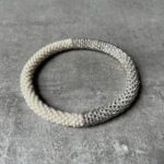 Nepal perle armbånd Nepal armbånd er en inspirerende og fascinerende smykkegenre, der vækker interessen hos smykkeentusiaster over hele verden. Disse håndlavede armbånd er kunstværker, der udstråler autenticitet, skønhed og dyb symbolik. Lad os dykke ned i den betagende verden af Nepal armbånd og udforske, hvad der gør dem så unikke og eftertragtede. Hvert Nepal armbånd er unikt, og det er netop denne individualitet, der appellerer til mange. Armbåndene er ofte skabt af dygtige nepalesiske håndværkere, der gennem generationer har forfinet deres teknikker til at skabe smykker af høj kvalitet. Disse håndværkere bruger traditionelle metoder, som har været en del af Nepals kultur og historie i århundreder. Processen er omhyggelig og kræver en stor grad af præcision og tålmodighed, hvilket gør hvert armbånd til en kærlighedsfyldt skabelse. Nepal armbånd er kendt for deres farverige og levende design. De er ofte dekoreret med perler, ædelstene, træ, metal eller andre naturlige materialer, hvilket giver dem et unikt udseende. Hvert enkelt element, der anvendes i armbåndene, er udvalgt omhyggeligt for at skabe en harmonisk kombination af farver og teksturer. Disse elementer er ofte inspireret af Nepals rige natur og kultur, hvilket giver armbåndene en autentisk følelse og en stærk forbindelse til landet. Symbolik spiller også en vigtig rolle i Nepal armbåndenes popularitet. Mange af armbåndene har indgraverede mønstre eller symboler, der repræsenterer vigtige aspekter af Nepals traditioner og spiritualitet. Disse symboler kan have betydning for held, lykke, kærlighed, beskyttelse eller en dybere forbindelse til naturen. At bære et Nepal armbånd kan derfor have en dybere betydning for bæreren og kan fungere som en påmindelse om deres forbindelse til Nepals rige arv. Nepal armbånd er ikke kun smukke smykker, men de har også en stærk social og kulturel betydning. Mange af disse smykker er håndlavede af kvinder, der er en del af samfundet i landområderne i Nepal. Produktionen af armbåndene giver disse kvinder mulighed for at skabe en bæredygtig indkomst, forbedre deres levevilkår og styrke deres selvstændighed. Når du køber et Nepal armbånd, bidrager du derfor til at støtte en positiv social indvirkning og bevare traditionelle håndværksmæssige metoder. Udover deres kulturelle og sociale betydning er Nepal armbånd også en favorit blandt modebevidste enkeltpersoner, der ønsker at tilføje en unik og autentisk touch til deres stil. Disse armbånd kan styles på utallige måder, uanset om du ønsker at skabe et bohemeinspireret look, en farverig festlig stil eller en subtil og elegant kombination. Der er et Nepal armbånd til enhver lejlighed og enhver personlig præference. I det store udvalg af smykker, der findes i dagens marked, skiller Nepal armbånd sig ud som en særlig perle. Deres håndlavede karakter, farverige design, dybe symbolik og sociale indvirkning gør dem til mere end bare smykker - de er en form for kunst og kultur, der fortæller historien om Nepal og dets folk. Ved at bære et Nepal armbånd, bærer du også med dig en del af dette rige og inspirerende land. Så uanset om du leder efter en meningsfuld gave eller ønsker at berige din egen smykkesamling, vil et Nepal armbånd være et mindeværdigt og værdsat valg.