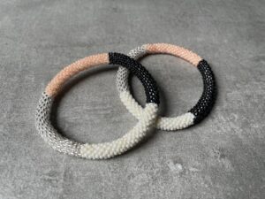Nepal perle armbånd Nepal armbånd er en inspirerende og fascinerende smykkegenre, der vækker interessen hos smykkeentusiaster over hele verden. Disse håndlavede armbånd er kunstværker, der udstråler autenticitet, skønhed og dyb symbolik. Lad os dykke ned i den betagende verden af Nepal armbånd og udforske, hvad der gør dem så unikke og eftertragtede. Hvert Nepal armbånd er unikt, og det er netop denne individualitet, der appellerer til mange. Armbåndene er ofte skabt af dygtige nepalesiske håndværkere, der gennem generationer har forfinet deres teknikker til at skabe smykker af høj kvalitet. Disse håndværkere bruger traditionelle metoder, som har været en del af Nepals kultur og historie i århundreder. Processen er omhyggelig og kræver en stor grad af præcision og tålmodighed, hvilket gør hvert armbånd til en kærlighedsfyldt skabelse. Nepal armbånd er kendt for deres farverige og levende design. De er ofte dekoreret med perler, ædelstene, træ, metal eller andre naturlige materialer, hvilket giver dem et unikt udseende. Hvert enkelt element, der anvendes i armbåndene, er udvalgt omhyggeligt for at skabe en harmonisk kombination af farver og teksturer. Disse elementer er ofte inspireret af Nepals rige natur og kultur, hvilket giver armbåndene en autentisk følelse og en stærk forbindelse til landet. Symbolik spiller også en vigtig rolle i Nepal armbåndenes popularitet. Mange af armbåndene har indgraverede mønstre eller symboler, der repræsenterer vigtige aspekter af Nepals traditioner og spiritualitet. Disse symboler kan have betydning for held, lykke, kærlighed, beskyttelse eller en dybere forbindelse til naturen. At bære et Nepal armbånd kan derfor have en dybere betydning for bæreren og kan fungere som en påmindelse om deres forbindelse til Nepals rige arv. Nepal armbånd er ikke kun smukke smykker, men de har også en stærk social og kulturel betydning. Mange af disse smykker er håndlavede af kvinder, der er en del af samfundet i landområderne i Nepal. Produktionen af armbåndene giver disse kvinder mulighed for at skabe en bæredygtig indkomst, forbedre deres levevilkår og styrke deres selvstændighed. Når du køber et Nepal armbånd, bidrager du derfor til at støtte en positiv social indvirkning og bevare traditionelle håndværksmæssige metoder. Udover deres kulturelle og sociale betydning er Nepal armbånd også en favorit blandt modebevidste enkeltpersoner, der ønsker at tilføje en unik og autentisk touch til deres stil. Disse armbånd kan styles på utallige måder, uanset om du ønsker at skabe et bohemeinspireret look, en farverig festlig stil eller en subtil og elegant kombination. Der er et Nepal armbånd til enhver lejlighed og enhver personlig præference. I det store udvalg af smykker, der findes i dagens marked, skiller Nepal armbånd sig ud som en særlig perle. Deres håndlavede karakter, farverige design, dybe symbolik og sociale indvirkning gør dem til mere end bare smykker - de er en form for kunst og kultur, der fortæller historien om Nepal og dets folk. Ved at bære et Nepal armbånd, bærer du også med dig en del af dette rige og inspirerende land. Så uanset om du leder efter en meningsfuld gave eller ønsker at berige din egen smykkesamling, vil et Nepal armbånd være et mindeværdigt og værdsat valg.