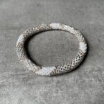 Nepal perle armbånd Nepal armbånd er en inspirerende og fascinerende smykkegenre, der vækker interessen hos smykkeentusiaster over hele verden. Disse håndlavede armbånd er kunstværker, der udstråler autenticitet, skønhed og dyb symbolik. Lad os dykke ned i den betagende verden af Nepal armbånd og udforske, hvad der gør dem så unikke og eftertragtede. Hvert Nepal armbånd er unikt, og det er netop denne individualitet, der appellerer til mange. Armbåndene er ofte skabt af dygtige nepalesiske håndværkere, der gennem generationer har forfinet deres teknikker til at skabe smykker af høj kvalitet. Disse håndværkere bruger traditionelle metoder, som har været en del af Nepals kultur og historie i århundreder. Processen er omhyggelig og kræver en stor grad af præcision og tålmodighed, hvilket gør hvert armbånd til en kærlighedsfyldt skabelse. Nepal armbånd er kendt for deres farverige og levende design. De er ofte dekoreret med perler, ædelstene, træ, metal eller andre naturlige materialer, hvilket giver dem et unikt udseende. Hvert enkelt element, der anvendes i armbåndene, er udvalgt omhyggeligt for at skabe en harmonisk kombination af farver og teksturer. Disse elementer er ofte inspireret af Nepals rige natur og kultur, hvilket giver armbåndene en autentisk følelse og en stærk forbindelse til landet. Symbolik spiller også en vigtig rolle i Nepal armbåndenes popularitet. Mange af armbåndene har indgraverede mønstre eller symboler, der repræsenterer vigtige aspekter af Nepals traditioner og spiritualitet. Disse symboler kan have betydning for held, lykke, kærlighed, beskyttelse eller en dybere forbindelse til naturen. At bære et Nepal armbånd kan derfor have en dybere betydning for bæreren og kan fungere som en påmindelse om deres forbindelse til Nepals rige arv. Nepal armbånd er ikke kun smukke smykker, men de har også en stærk social og kulturel betydning. Mange af disse smykker er håndlavede af kvinder, der er en del af samfundet i landområderne i Nepal. Produktionen af armbåndene giver disse kvinder mulighed for at skabe en bæredygtig indkomst, forbedre deres levevilkår og styrke deres selvstændighed. Når du køber et Nepal armbånd, bidrager du derfor til at støtte en positiv social indvirkning og bevare traditionelle håndværksmæssige metoder. Udover deres kulturelle og sociale betydning er Nepal armbånd også en favorit blandt modebevidste enkeltpersoner, der ønsker at tilføje en unik og autentisk touch til deres stil. Disse armbånd kan styles på utallige måder, uanset om du ønsker at skabe et bohemeinspireret look, en farverig festlig stil eller en subtil og elegant kombination. Der er et Nepal armbånd til enhver lejlighed og enhver personlig præference. I det store udvalg af smykker, der findes i dagens marked, skiller Nepal armbånd sig ud som en særlig perle. Deres håndlavede karakter, farverige design, dybe symbolik og sociale indvirkning gør dem til mere end bare smykker - de er en form for kunst og kultur, der fortæller historien om Nepal og dets folk. Ved at bære et Nepal armbånd, bærer du også med dig en del af dette rige og inspirerende land. Så uanset om du leder efter en meningsfuld gave eller ønsker at berige din egen smykkesamling, vil et Nepal armbånd være et mindeværdigt og værdsat valg.