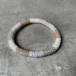 Nepal perle armbånd Nepal armbånd er en inspirerende og fascinerende smykkegenre, der vækker interessen hos smykkeentusiaster over hele verden. Disse håndlavede armbånd er kunstværker, der udstråler autenticitet, skønhed og dyb symbolik. Lad os dykke ned i den betagende verden af Nepal armbånd og udforske, hvad der gør dem så unikke og eftertragtede. Hvert Nepal armbånd er unikt, og det er netop denne individualitet, der appellerer til mange. Armbåndene er ofte skabt af dygtige nepalesiske håndværkere, der gennem generationer har forfinet deres teknikker til at skabe smykker af høj kvalitet. Disse håndværkere bruger traditionelle metoder, som har været en del af Nepals kultur og historie i århundreder. Processen er omhyggelig og kræver en stor grad af præcision og tålmodighed, hvilket gør hvert armbånd til en kærlighedsfyldt skabelse. Nepal armbånd er kendt for deres farverige og levende design. De er ofte dekoreret med perler, ædelstene, træ, metal eller andre naturlige materialer, hvilket giver dem et unikt udseende. Hvert enkelt element, der anvendes i armbåndene, er udvalgt omhyggeligt for at skabe en harmonisk kombination af farver og teksturer. Disse elementer er ofte inspireret af Nepals rige natur og kultur, hvilket giver armbåndene en autentisk følelse og en stærk forbindelse til landet. Symbolik spiller også en vigtig rolle i Nepal armbåndenes popularitet. Mange af armbåndene har indgraverede mønstre eller symboler, der repræsenterer vigtige aspekter af Nepals traditioner og spiritualitet. Disse symboler kan have betydning for held, lykke, kærlighed, beskyttelse eller en dybere forbindelse til naturen. At bære et Nepal armbånd kan derfor have en dybere betydning for bæreren og kan fungere som en påmindelse om deres forbindelse til Nepals rige arv. Nepal armbånd er ikke kun smukke smykker, men de har også en stærk social og kulturel betydning. Mange af disse smykker er håndlavede af kvinder, der er en del af samfundet i landområderne i Nepal. Produktionen af armbåndene giver disse kvinder mulighed for at skabe en bæredygtig indkomst, forbedre deres levevilkår og styrke deres selvstændighed. Når du køber et Nepal armbånd, bidrager du derfor til at støtte en positiv social indvirkning og bevare traditionelle håndværksmæssige metoder. Udover deres kulturelle og sociale betydning er Nepal armbånd også en favorit blandt modebevidste enkeltpersoner, der ønsker at tilføje en unik og autentisk touch til deres stil. Disse armbånd kan styles på utallige måder, uanset om du ønsker at skabe et bohemeinspireret look, en farverig festlig stil eller en subtil og elegant kombination. Der er et Nepal armbånd til enhver lejlighed og enhver personlig præference. I det store udvalg af smykker, der findes i dagens marked, skiller Nepal armbånd sig ud som en særlig perle. Deres håndlavede karakter, farverige design, dybe symbolik og sociale indvirkning gør dem til mere end bare smykker - de er en form for kunst og kultur, der fortæller historien om Nepal og dets folk. Ved at bære et Nepal armbånd, bærer du også med dig en del af dette rige og inspirerende land. Så uanset om du leder efter en meningsfuld gave eller ønsker at berige din egen smykkesamling, vil et Nepal armbånd være et mindeværdigt og værdsat valg.