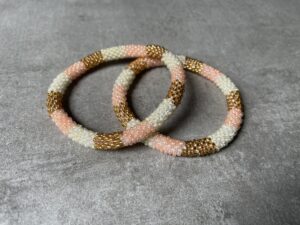 Nepal perle armbånd Nepal armbånd er en inspirerende og fascinerende smykkegenre, der vækker interessen hos smykkeentusiaster over hele verden. Disse håndlavede armbånd er kunstværker, der udstråler autenticitet, skønhed og dyb symbolik. Lad os dykke ned i den betagende verden af Nepal armbånd og udforske, hvad der gør dem så unikke og eftertragtede. Hvert Nepal armbånd er unikt, og det er netop denne individualitet, der appellerer til mange. Armbåndene er ofte skabt af dygtige nepalesiske håndværkere, der gennem generationer har forfinet deres teknikker til at skabe smykker af høj kvalitet. Disse håndværkere bruger traditionelle metoder, som har været en del af Nepals kultur og historie i århundreder. Processen er omhyggelig og kræver en stor grad af præcision og tålmodighed, hvilket gør hvert armbånd til en kærlighedsfyldt skabelse. Nepal armbånd er kendt for deres farverige og levende design. De er ofte dekoreret med perler, ædelstene, træ, metal eller andre naturlige materialer, hvilket giver dem et unikt udseende. Hvert enkelt element, der anvendes i armbåndene, er udvalgt omhyggeligt for at skabe en harmonisk kombination af farver og teksturer. Disse elementer er ofte inspireret af Nepals rige natur og kultur, hvilket giver armbåndene en autentisk følelse og en stærk forbindelse til landet. Symbolik spiller også en vigtig rolle i Nepal armbåndenes popularitet. Mange af armbåndene har indgraverede mønstre eller symboler, der repræsenterer vigtige aspekter af Nepals traditioner og spiritualitet. Disse symboler kan have betydning for held, lykke, kærlighed, beskyttelse eller en dybere forbindelse til naturen. At bære et Nepal armbånd kan derfor have en dybere betydning for bæreren og kan fungere som en påmindelse om deres forbindelse til Nepals rige arv. Nepal armbånd er ikke kun smukke smykker, men de har også en stærk social og kulturel betydning. Mange af disse smykker er håndlavede af kvinder, der er en del af samfundet i landområderne i Nepal. Produktionen af armbåndene giver disse kvinder mulighed for at skabe en bæredygtig indkomst, forbedre deres levevilkår og styrke deres selvstændighed. Når du køber et Nepal armbånd, bidrager du derfor til at støtte en positiv social indvirkning og bevare traditionelle håndværksmæssige metoder. Udover deres kulturelle og sociale betydning er Nepal armbånd også en favorit blandt modebevidste enkeltpersoner, der ønsker at tilføje en unik og autentisk touch til deres stil. Disse armbånd kan styles på utallige måder, uanset om du ønsker at skabe et bohemeinspireret look, en farverig festlig stil eller en subtil og elegant kombination. Der er et Nepal armbånd til enhver lejlighed og enhver personlig præference. I det store udvalg af smykker, der findes i dagens marked, skiller Nepal armbånd sig ud som en særlig perle. Deres håndlavede karakter, farverige design, dybe symbolik og sociale indvirkning gør dem til mere end bare smykker - de er en form for kunst og kultur, der fortæller historien om Nepal og dets folk. Ved at bære et Nepal armbånd, bærer du også med dig en del af dette rige og inspirerende land. Så uanset om du leder efter en meningsfuld gave eller ønsker at berige din egen smykkesamling, vil et Nepal armbånd være et mindeværdigt og værdsat valg.