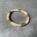Nepal perle armbånd Nepal armbånd er en inspirerende og fascinerende smykkegenre, der vækker interessen hos smykkeentusiaster over hele verden. Disse håndlavede armbånd er kunstværker, der udstråler autenticitet, skønhed og dyb symbolik. Lad os dykke ned i den betagende verden af Nepal armbånd og udforske, hvad der gør dem så unikke og eftertragtede. Hvert Nepal armbånd er unikt, og det er netop denne individualitet, der appellerer til mange. Armbåndene er ofte skabt af dygtige nepalesiske håndværkere, der gennem generationer har forfinet deres teknikker til at skabe smykker af høj kvalitet. Disse håndværkere bruger traditionelle metoder, som har været en del af Nepals kultur og historie i århundreder. Processen er omhyggelig og kræver en stor grad af præcision og tålmodighed, hvilket gør hvert armbånd til en kærlighedsfyldt skabelse. Nepal armbånd er kendt for deres farverige og levende design. De er ofte dekoreret med perler, ædelstene, træ, metal eller andre naturlige materialer, hvilket giver dem et unikt udseende. Hvert enkelt element, der anvendes i armbåndene, er udvalgt omhyggeligt for at skabe en harmonisk kombination af farver og teksturer. Disse elementer er ofte inspireret af Nepals rige natur og kultur, hvilket giver armbåndene en autentisk følelse og en stærk forbindelse til landet. Symbolik spiller også en vigtig rolle i Nepal armbåndenes popularitet. Mange af armbåndene har indgraverede mønstre eller symboler, der repræsenterer vigtige aspekter af Nepals traditioner og spiritualitet. Disse symboler kan have betydning for held, lykke, kærlighed, beskyttelse eller en dybere forbindelse til naturen. At bære et Nepal armbånd kan derfor have en dybere betydning for bæreren og kan fungere som en påmindelse om deres forbindelse til Nepals rige arv. Nepal armbånd er ikke kun smukke smykker, men de har også en stærk social og kulturel betydning. Mange af disse smykker er håndlavede af kvinder, der er en del af samfundet i landområderne i Nepal. Produktionen af armbåndene giver disse kvinder mulighed for at skabe en bæredygtig indkomst, forbedre deres levevilkår og styrke deres selvstændighed. Når du køber et Nepal armbånd, bidrager du derfor til at støtte en positiv social indvirkning og bevare traditionelle håndværksmæssige metoder. Udover deres kulturelle og sociale betydning er Nepal armbånd også en favorit blandt modebevidste enkeltpersoner, der ønsker at tilføje en unik og autentisk touch til deres stil. Disse armbånd kan styles på utallige måder, uanset om du ønsker at skabe et bohemeinspireret look, en farverig festlig stil eller en subtil og elegant kombination. Der er et Nepal armbånd til enhver lejlighed og enhver personlig præference. I det store udvalg af smykker, der findes i dagens marked, skiller Nepal armbånd sig ud som en særlig perle. Deres håndlavede karakter, farverige design, dybe symbolik og sociale indvirkning gør dem til mere end bare smykker - de er en form for kunst og kultur, der fortæller historien om Nepal og dets folk. Ved at bære et Nepal armbånd, bærer du også med dig en del af dette rige og inspirerende land. Så uanset om du leder efter en meningsfuld gave eller ønsker at berige din egen smykkesamling, vil et Nepal armbånd være et mindeværdigt og værdsat valg.