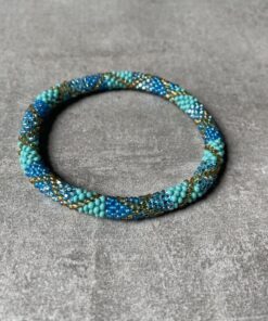 Nepal perle armbånd Nepal armbånd er en inspirerende og fascinerende smykkegenre, der vækker interessen hos smykkeentusiaster over hele verden. Disse håndlavede armbånd er kunstværker, der udstråler autenticitet, skønhed og dyb symbolik. Lad os dykke ned i den betagende verden af Nepal armbånd og udforske, hvad der gør dem så unikke og eftertragtede. Hvert Nepal armbånd er unikt, og det er netop denne individualitet, der appellerer til mange. Armbåndene er ofte skabt af dygtige nepalesiske håndværkere, der gennem generationer har forfinet deres teknikker til at skabe smykker af høj kvalitet. Disse håndværkere bruger traditionelle metoder, som har været en del af Nepals kultur og historie i århundreder. Processen er omhyggelig og kræver en stor grad af præcision og tålmodighed, hvilket gør hvert armbånd til en kærlighedsfyldt skabelse. Nepal armbånd er kendt for deres farverige og levende design. De er ofte dekoreret med perler, ædelstene, træ, metal eller andre naturlige materialer, hvilket giver dem et unikt udseende. Hvert enkelt element, der anvendes i armbåndene, er udvalgt omhyggeligt for at skabe en harmonisk kombination af farver og teksturer. Disse elementer er ofte inspireret af Nepals rige natur og kultur, hvilket giver armbåndene en autentisk følelse og en stærk forbindelse til landet. Symbolik spiller også en vigtig rolle i Nepal armbåndenes popularitet. Mange af armbåndene har indgraverede mønstre eller symboler, der repræsenterer vigtige aspekter af Nepals traditioner og spiritualitet. Disse symboler kan have betydning for held, lykke, kærlighed, beskyttelse eller en dybere forbindelse til naturen. At bære et Nepal armbånd kan derfor have en dybere betydning for bæreren og kan fungere som en påmindelse om deres forbindelse til Nepals rige arv. Nepal armbånd er ikke kun smukke smykker, men de har også en stærk social og kulturel betydning. Mange af disse smykker er håndlavede af kvinder, der er en del af samfundet i landområderne i Nepal. Produktionen af armbåndene giver disse kvinder mulighed for at skabe en bæredygtig indkomst, forbedre deres levevilkår og styrke deres selvstændighed. Når du køber et Nepal armbånd, bidrager du derfor til at støtte en positiv social indvirkning og bevare traditionelle håndværksmæssige metoder. Udover deres kulturelle og sociale betydning er Nepal armbånd også en favorit blandt modebevidste enkeltpersoner, der ønsker at tilføje en unik og autentisk touch til deres stil. Disse armbånd kan styles på utallige måder, uanset om du ønsker at skabe et bohemeinspireret look, en farverig festlig stil eller en subtil og elegant kombination. Der er et Nepal armbånd til enhver lejlighed og enhver personlig præference. I det store udvalg af smykker, der findes i dagens marked, skiller Nepal armbånd sig ud som en særlig perle. Deres håndlavede karakter, farverige design, dybe symbolik og sociale indvirkning gør dem til mere end bare smykker - de er en form for kunst og kultur, der fortæller historien om Nepal og dets folk. Ved at bære et Nepal armbånd, bærer du også med dig en del af dette rige og inspirerende land. Så uanset om du leder efter en meningsfuld gave eller ønsker at berige din egen smykkesamling, vil et Nepal armbånd være et mindeværdigt og værdsat valg.