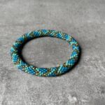 Nepal perle armbånd Nepal armbånd er en inspirerende og fascinerende smykkegenre, der vækker interessen hos smykkeentusiaster over hele verden. Disse håndlavede armbånd er kunstværker, der udstråler autenticitet, skønhed og dyb symbolik. Lad os dykke ned i den betagende verden af Nepal armbånd og udforske, hvad der gør dem så unikke og eftertragtede. Hvert Nepal armbånd er unikt, og det er netop denne individualitet, der appellerer til mange. Armbåndene er ofte skabt af dygtige nepalesiske håndværkere, der gennem generationer har forfinet deres teknikker til at skabe smykker af høj kvalitet. Disse håndværkere bruger traditionelle metoder, som har været en del af Nepals kultur og historie i århundreder. Processen er omhyggelig og kræver en stor grad af præcision og tålmodighed, hvilket gør hvert armbånd til en kærlighedsfyldt skabelse. Nepal armbånd er kendt for deres farverige og levende design. De er ofte dekoreret med perler, ædelstene, træ, metal eller andre naturlige materialer, hvilket giver dem et unikt udseende. Hvert enkelt element, der anvendes i armbåndene, er udvalgt omhyggeligt for at skabe en harmonisk kombination af farver og teksturer. Disse elementer er ofte inspireret af Nepals rige natur og kultur, hvilket giver armbåndene en autentisk følelse og en stærk forbindelse til landet. Symbolik spiller også en vigtig rolle i Nepal armbåndenes popularitet. Mange af armbåndene har indgraverede mønstre eller symboler, der repræsenterer vigtige aspekter af Nepals traditioner og spiritualitet. Disse symboler kan have betydning for held, lykke, kærlighed, beskyttelse eller en dybere forbindelse til naturen. At bære et Nepal armbånd kan derfor have en dybere betydning for bæreren og kan fungere som en påmindelse om deres forbindelse til Nepals rige arv. Nepal armbånd er ikke kun smukke smykker, men de har også en stærk social og kulturel betydning. Mange af disse smykker er håndlavede af kvinder, der er en del af samfundet i landområderne i Nepal. Produktionen af armbåndene giver disse kvinder mulighed for at skabe en bæredygtig indkomst, forbedre deres levevilkår og styrke deres selvstændighed. Når du køber et Nepal armbånd, bidrager du derfor til at støtte en positiv social indvirkning og bevare traditionelle håndværksmæssige metoder. Udover deres kulturelle og sociale betydning er Nepal armbånd også en favorit blandt modebevidste enkeltpersoner, der ønsker at tilføje en unik og autentisk touch til deres stil. Disse armbånd kan styles på utallige måder, uanset om du ønsker at skabe et bohemeinspireret look, en farverig festlig stil eller en subtil og elegant kombination. Der er et Nepal armbånd til enhver lejlighed og enhver personlig præference. I det store udvalg af smykker, der findes i dagens marked, skiller Nepal armbånd sig ud som en særlig perle. Deres håndlavede karakter, farverige design, dybe symbolik og sociale indvirkning gør dem til mere end bare smykker - de er en form for kunst og kultur, der fortæller historien om Nepal og dets folk. Ved at bære et Nepal armbånd, bærer du også med dig en del af dette rige og inspirerende land. Så uanset om du leder efter en meningsfuld gave eller ønsker at berige din egen smykkesamling, vil et Nepal armbånd være et mindeværdigt og værdsat valg.