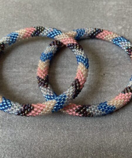 Nepal armbånd er en inspirerende og fascinerende smykkegenre, der vækker interessen hos smykkeentusiaster over hele verden. Disse håndlavede armbånd er kunstværker, der udstråler autenticitet, skønhed og dyb symbolik. Lad os dykke ned i den betagende verden af Nepal armbånd og udforske, hvad der gør dem så unikke og eftertragtede. Hvert Nepal armbånd er unikt, og det er netop denne individualitet, der appellerer til mange. Armbåndene er ofte skabt af dygtige nepalesiske håndværkere, der gennem generationer har forfinet deres teknikker til at skabe smykker af høj kvalitet. Disse håndværkere bruger traditionelle metoder, som har været en del af Nepals kultur og historie i århundreder. Processen er omhyggelig og kræver en stor grad af præcision og tålmodighed, hvilket gør hvert armbånd til en kærlighedsfyldt skabelse. Nepal armbånd er kendt for deres farverige og levende design. De er ofte dekoreret med perler, ædelstene, træ, metal eller andre naturlige materialer, hvilket giver dem et unikt udseende. Hvert enkelt element, der anvendes i armbåndene, er udvalgt omhyggeligt for at skabe en harmonisk kombination af farver og teksturer. Disse elementer er ofte inspireret af Nepals rige natur og kultur, hvilket giver armbåndene en autentisk følelse og en stærk forbindelse til landet. Symbolik spiller også en vigtig rolle i Nepal armbåndenes popularitet. Mange af armbåndene har indgraverede mønstre eller symboler, der repræsenterer vigtige aspekter af Nepals traditioner og spiritualitet. Disse symboler kan have betydning for held, lykke, kærlighed, beskyttelse eller en dybere forbindelse til naturen. At bære et Nepal armbånd kan derfor have en dybere betydning for bæreren og kan fungere som en påmindelse om deres forbindelse til Nepals rige arv. Nepal armbånd er ikke kun smukke smykker, men de har også en stærk social og kulturel betydning. Mange af disse smykker er håndlavede af kvinder, der er en del af samfundet i landområderne i Nepal. Produktionen af armbåndene giver disse kvinder mulighed for at skabe en bæredygtig indkomst, forbedre deres levevilkår og styrke deres selvstændighed. Når du køber et Nepal armbånd, bidrager du derfor til at støtte en positiv social indvirkning og bevare traditionelle håndværksmæssige metoder. Udover deres kulturelle og sociale betydning er Nepal armbånd også en favorit blandt modebevidste enkeltpersoner, der ønsker at tilføje en unik og autentisk touch til deres stil. Disse armbånd kan styles på utallige måder, uanset om du ønsker at skabe et bohemeinspireret look, en farverig festlig stil eller en subtil og elegant kombination. Der er et Nepal armbånd til enhver lejlighed og enhver personlig præference. I det store udvalg af smykker, der findes i dagens marked, skiller Nepal armbånd sig ud som en særlig perle. Deres håndlavede karakter, farverige design, dybe symbolik og sociale indvirkning gør dem til mere end bare smykker - de er en form for kunst og kultur, der fortæller historien om Nepal og dets folk. Ved at bære et Nepal armbånd, bærer du også med dig en del af dette rige og inspirerende land. Så uanset om du leder efter en meningsfuld gave eller ønsker at berige din egen smykkesamling, vil et Nepal armbånd være et mindeværdigt og værdsat valg.