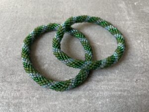 Nepal armbånd er en inspirerende og fascinerende smykkegenre, der vækker interessen hos smykkeentusiaster over hele verden. Disse håndlavede armbånd er kunstværker, der udstråler autenticitet, skønhed og dyb symbolik. Lad os dykke ned i den betagende verden af Nepal armbånd og udforske, hvad der gør dem så unikke og eftertragtede. Hvert Nepal armbånd er unikt, og det er netop denne individualitet, der appellerer til mange. Armbåndene er ofte skabt af dygtige nepalesiske håndværkere, der gennem generationer har forfinet deres teknikker til at skabe smykker af høj kvalitet. Disse håndværkere bruger traditionelle metoder, som har været en del af Nepals kultur og historie i århundreder. Processen er omhyggelig og kræver en stor grad af præcision og tålmodighed, hvilket gør hvert armbånd til en kærlighedsfyldt skabelse. Nepal armbånd er kendt for deres farverige og levende design. De er ofte dekoreret med perler, ædelstene, træ, metal eller andre naturlige materialer, hvilket giver dem et unikt udseende. Hvert enkelt element, der anvendes i armbåndene, er udvalgt omhyggeligt for at skabe en harmonisk kombination af farver og teksturer. Disse elementer er ofte inspireret af Nepals rige natur og kultur, hvilket giver armbåndene en autentisk følelse og en stærk forbindelse til landet. Symbolik spiller også en vigtig rolle i Nepal armbåndenes popularitet. Mange af armbåndene har indgraverede mønstre eller symboler, der repræsenterer vigtige aspekter af Nepals traditioner og spiritualitet. Disse symboler kan have betydning for held, lykke, kærlighed, beskyttelse eller en dybere forbindelse til naturen. At bære et Nepal armbånd kan derfor have en dybere betydning for bæreren og kan fungere som en påmindelse om deres forbindelse til Nepals rige arv. Nepal armbånd er ikke kun smukke smykker, men de har også en stærk social og kulturel betydning. Mange af disse smykker er håndlavede af kvinder, der er en del af samfundet i landområderne i Nepal. Produktionen af armbåndene giver disse kvinder mulighed for at skabe en bæredygtig indkomst, forbedre deres levevilkår og styrke deres selvstændighed. Når du køber et Nepal armbånd, bidrager du derfor til at støtte en positiv social indvirkning og bevare traditionelle håndværksmæssige metoder. Udover deres kulturelle og sociale betydning er Nepal armbånd også en favorit blandt modebevidste enkeltpersoner, der ønsker at tilføje en unik og autentisk touch til deres stil. Disse armbånd kan styles på utallige måder, uanset om du ønsker at skabe et bohemeinspireret look, en farverig festlig stil eller en subtil og elegant kombination. Der er et Nepal armbånd til enhver lejlighed og enhver personlig præference. I det store udvalg af smykker, der findes i dagens marked, skiller Nepal armbånd sig ud som en særlig perle. Deres håndlavede karakter, farverige design, dybe symbolik og sociale indvirkning gør dem til mere end bare smykker - de er en form for kunst og kultur, der fortæller historien om Nepal og dets folk. Ved at bære et Nepal armbånd, bærer du også med dig en del af dette rige og inspirerende land. Så uanset om du leder efter en meningsfuld gave eller ønsker at berige din egen smykkesamling, vil et Nepal armbånd være et mindeværdigt og værdsat valg.