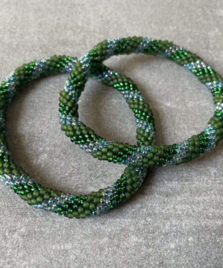 Nepal armbånd er en inspirerende og fascinerende smykkegenre, der vækker interessen hos smykkeentusiaster over hele verden. Disse håndlavede armbånd er kunstværker, der udstråler autenticitet, skønhed og dyb symbolik. Lad os dykke ned i den betagende verden af Nepal armbånd og udforske, hvad der gør dem så unikke og eftertragtede. Hvert Nepal armbånd er unikt, og det er netop denne individualitet, der appellerer til mange. Armbåndene er ofte skabt af dygtige nepalesiske håndværkere, der gennem generationer har forfinet deres teknikker til at skabe smykker af høj kvalitet. Disse håndværkere bruger traditionelle metoder, som har været en del af Nepals kultur og historie i århundreder. Processen er omhyggelig og kræver en stor grad af præcision og tålmodighed, hvilket gør hvert armbånd til en kærlighedsfyldt skabelse. Nepal armbånd er kendt for deres farverige og levende design. De er ofte dekoreret med perler, ædelstene, træ, metal eller andre naturlige materialer, hvilket giver dem et unikt udseende. Hvert enkelt element, der anvendes i armbåndene, er udvalgt omhyggeligt for at skabe en harmonisk kombination af farver og teksturer. Disse elementer er ofte inspireret af Nepals rige natur og kultur, hvilket giver armbåndene en autentisk følelse og en stærk forbindelse til landet. Symbolik spiller også en vigtig rolle i Nepal armbåndenes popularitet. Mange af armbåndene har indgraverede mønstre eller symboler, der repræsenterer vigtige aspekter af Nepals traditioner og spiritualitet. Disse symboler kan have betydning for held, lykke, kærlighed, beskyttelse eller en dybere forbindelse til naturen. At bære et Nepal armbånd kan derfor have en dybere betydning for bæreren og kan fungere som en påmindelse om deres forbindelse til Nepals rige arv. Nepal armbånd er ikke kun smukke smykker, men de har også en stærk social og kulturel betydning. Mange af disse smykker er håndlavede af kvinder, der er en del af samfundet i landområderne i Nepal. Produktionen af armbåndene giver disse kvinder mulighed for at skabe en bæredygtig indkomst, forbedre deres levevilkår og styrke deres selvstændighed. Når du køber et Nepal armbånd, bidrager du derfor til at støtte en positiv social indvirkning og bevare traditionelle håndværksmæssige metoder. Udover deres kulturelle og sociale betydning er Nepal armbånd også en favorit blandt modebevidste enkeltpersoner, der ønsker at tilføje en unik og autentisk touch til deres stil. Disse armbånd kan styles på utallige måder, uanset om du ønsker at skabe et bohemeinspireret look, en farverig festlig stil eller en subtil og elegant kombination. Der er et Nepal armbånd til enhver lejlighed og enhver personlig præference. I det store udvalg af smykker, der findes i dagens marked, skiller Nepal armbånd sig ud som en særlig perle. Deres håndlavede karakter, farverige design, dybe symbolik og sociale indvirkning gør dem til mere end bare smykker - de er en form for kunst og kultur, der fortæller historien om Nepal og dets folk. Ved at bære et Nepal armbånd, bærer du også med dig en del af dette rige og inspirerende land. Så uanset om du leder efter en meningsfuld gave eller ønsker at berige din egen smykkesamling, vil et Nepal armbånd være et mindeværdigt og værdsat valg.