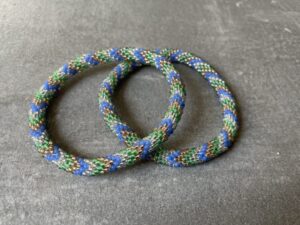 Nepal armbånd er en inspirerende og fascinerende smykkegenre, der vækker interessen hos smykkeentusiaster over hele verden. Disse håndlavede armbånd er kunstværker, der udstråler autenticitet, skønhed og dyb symbolik. Lad os dykke ned i den betagende verden af Nepal armbånd og udforske, hvad der gør dem så unikke og eftertragtede. Hvert Nepal armbånd er unikt, og det er netop denne individualitet, der appellerer til mange. Armbåndene er ofte skabt af dygtige nepalesiske håndværkere, der gennem generationer har forfinet deres teknikker til at skabe smykker af høj kvalitet. Disse håndværkere bruger traditionelle metoder, som har været en del af Nepals kultur og historie i århundreder. Processen er omhyggelig og kræver en stor grad af præcision og tålmodighed, hvilket gør hvert armbånd til en kærlighedsfyldt skabelse. Nepal armbånd er kendt for deres farverige og levende design. De er ofte dekoreret med perler, ædelstene, træ, metal eller andre naturlige materialer, hvilket giver dem et unikt udseende. Hvert enkelt element, der anvendes i armbåndene, er udvalgt omhyggeligt for at skabe en harmonisk kombination af farver og teksturer. Disse elementer er ofte inspireret af Nepals rige natur og kultur, hvilket giver armbåndene en autentisk følelse og en stærk forbindelse til landet. Symbolik spiller også en vigtig rolle i Nepal armbåndenes popularitet. Mange af armbåndene har indgraverede mønstre eller symboler, der repræsenterer vigtige aspekter af Nepals traditioner og spiritualitet. Disse symboler kan have betydning for held, lykke, kærlighed, beskyttelse eller en dybere forbindelse til naturen. At bære et Nepal armbånd kan derfor have en dybere betydning for bæreren og kan fungere som en påmindelse om deres forbindelse til Nepals rige arv. Nepal armbånd er ikke kun smukke smykker, men de har også en stærk social og kulturel betydning. Mange af disse smykker er håndlavede af kvinder, der er en del af samfundet i landområderne i Nepal. Produktionen af armbåndene giver disse kvinder mulighed for at skabe en bæredygtig indkomst, forbedre deres levevilkår og styrke deres selvstændighed. Når du køber et Nepal armbånd, bidrager du derfor til at støtte en positiv social indvirkning og bevare traditionelle håndværksmæssige metoder. Udover deres kulturelle og sociale betydning er Nepal armbånd også en favorit blandt modebevidste enkeltpersoner, der ønsker at tilføje en unik og autentisk touch til deres stil. Disse armbånd kan styles på utallige måder, uanset om du ønsker at skabe et bohemeinspireret look, en farverig festlig stil eller en subtil og elegant kombination. Der er et Nepal armbånd til enhver lejlighed og enhver personlig præference. I det store udvalg af smykker, der findes i dagens marked, skiller Nepal armbånd sig ud som en særlig perle. Deres håndlavede karakter, farverige design, dybe symbolik og sociale indvirkning gør dem til mere end bare smykker - de er en form for kunst og kultur, der fortæller historien om Nepal og dets folk. Ved at bære et Nepal armbånd, bærer du også med dig en del af dette rige og inspirerende land. Så uanset om du leder efter en meningsfuld gave eller ønsker at berige din egen smykkesamling, vil et Nepal armbånd være et mindeværdigt og værdsat valg.